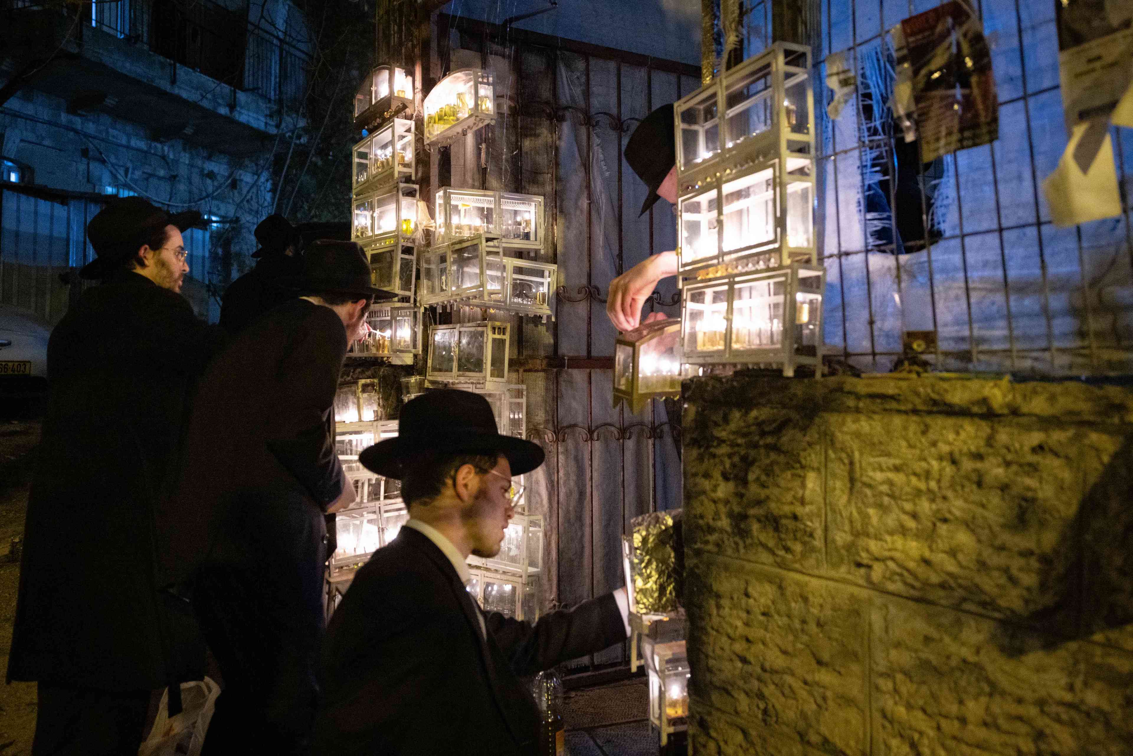 Ultra-Orthodox Jews light candles during the Jewish holiday of Hanukkah, in Jerusalem's Mea Shearim neighbourhood on December 28, 2024 background
