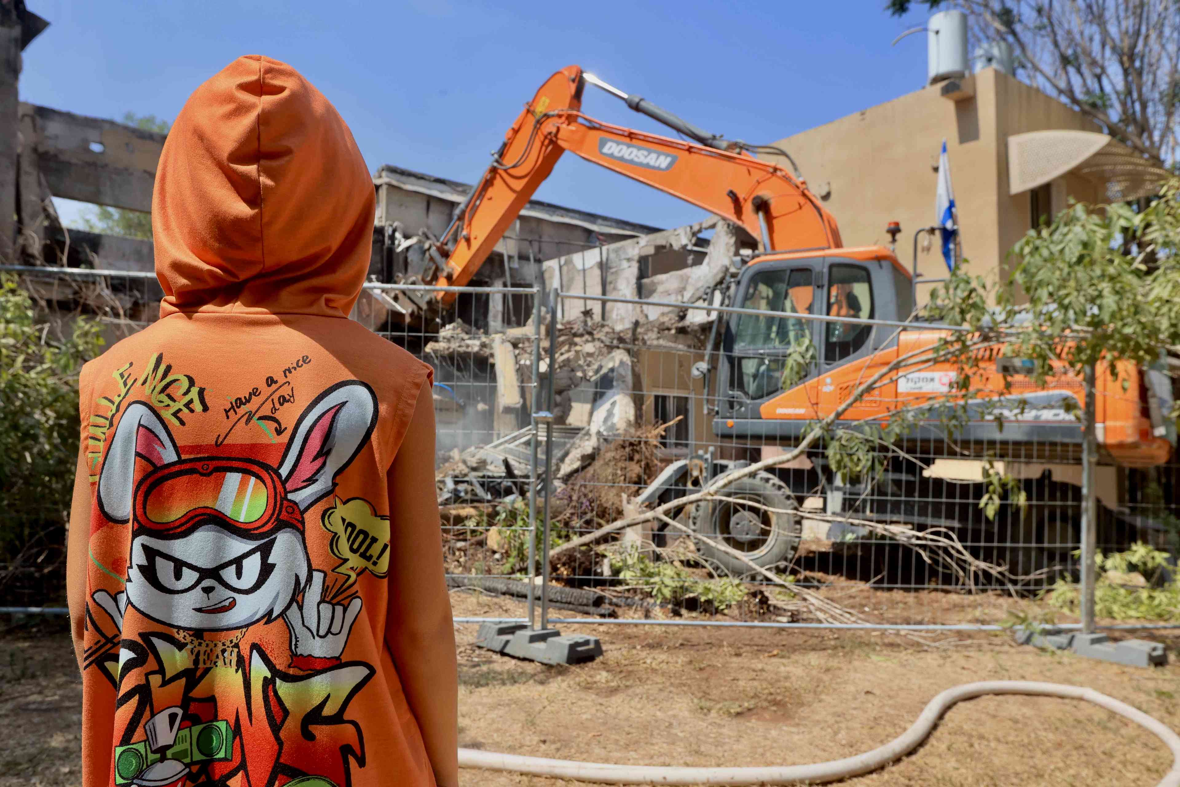 A bulldozer destroys a house that was damaged during the 7th of October massacre in Kibbutz Be'eri, July 7, 2024.