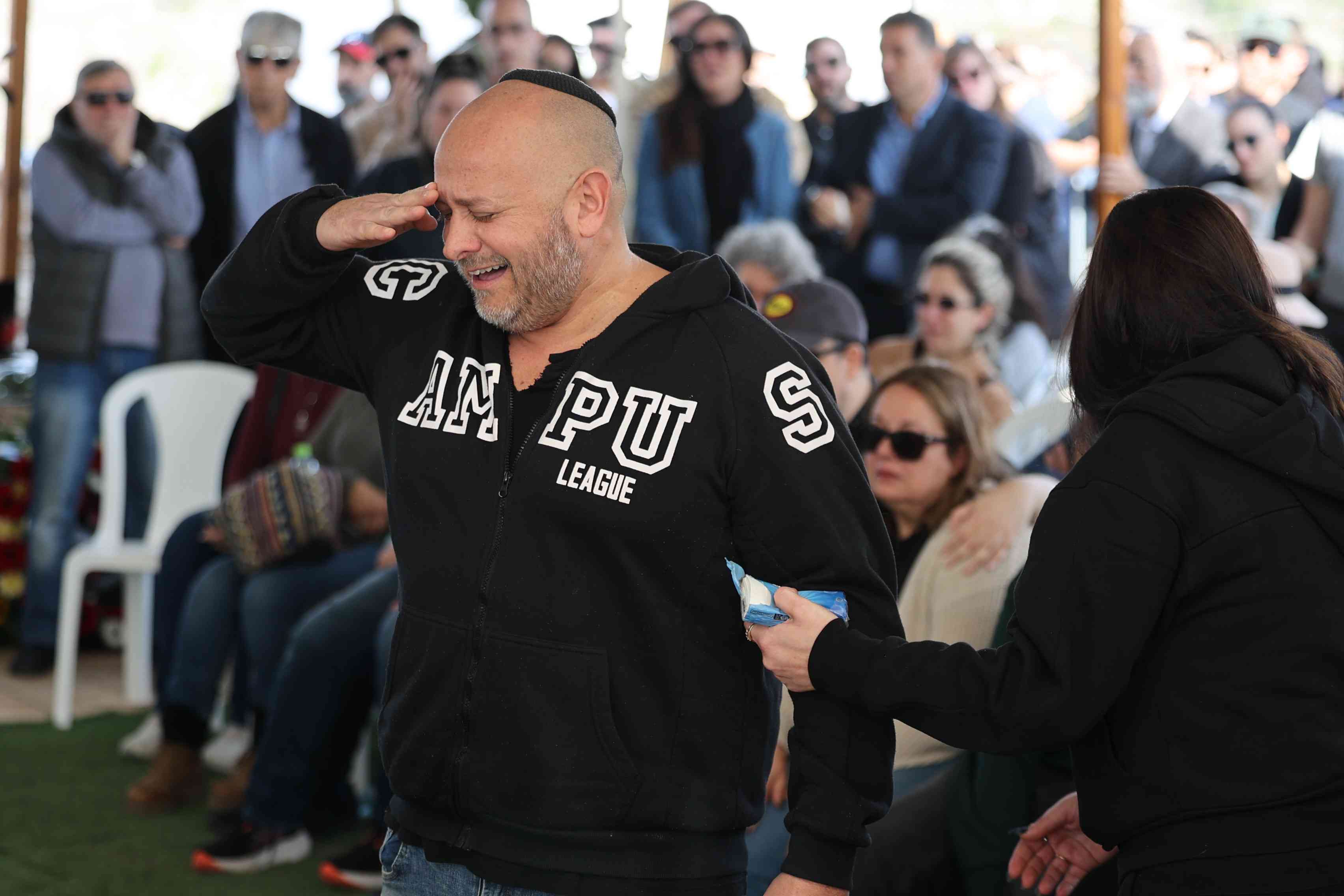 Family and friends attend the funeral of Israeli soldier Sergeant Yahav Maayan, at the military cemetery in Modi'in on January 12, 2024. He was killed during a ground operation in the Gaza Strip.  background