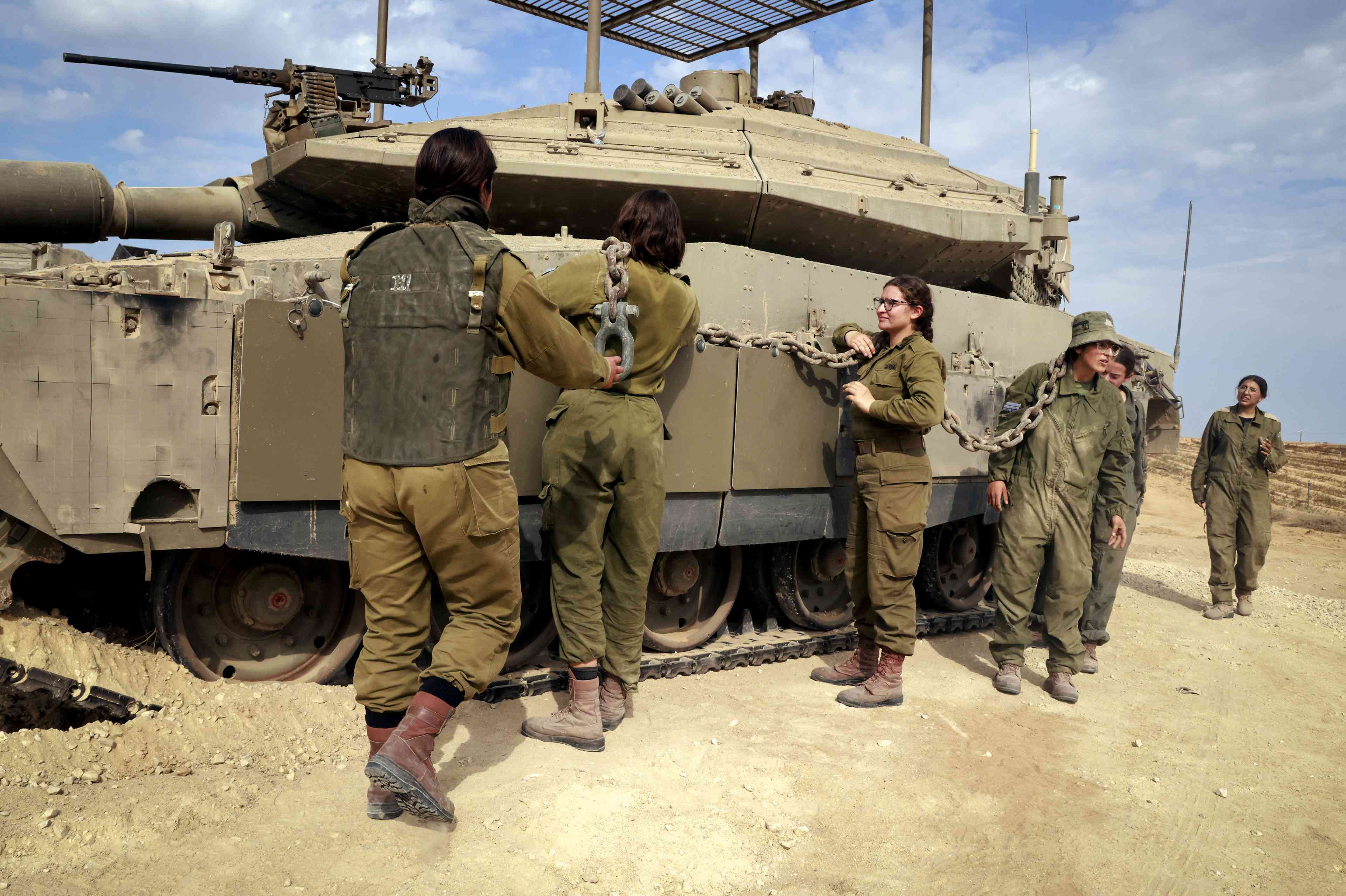 Israeli soldiers from the Caracal Battalion working near their tank near the Israeli border with Egypt and Gaza