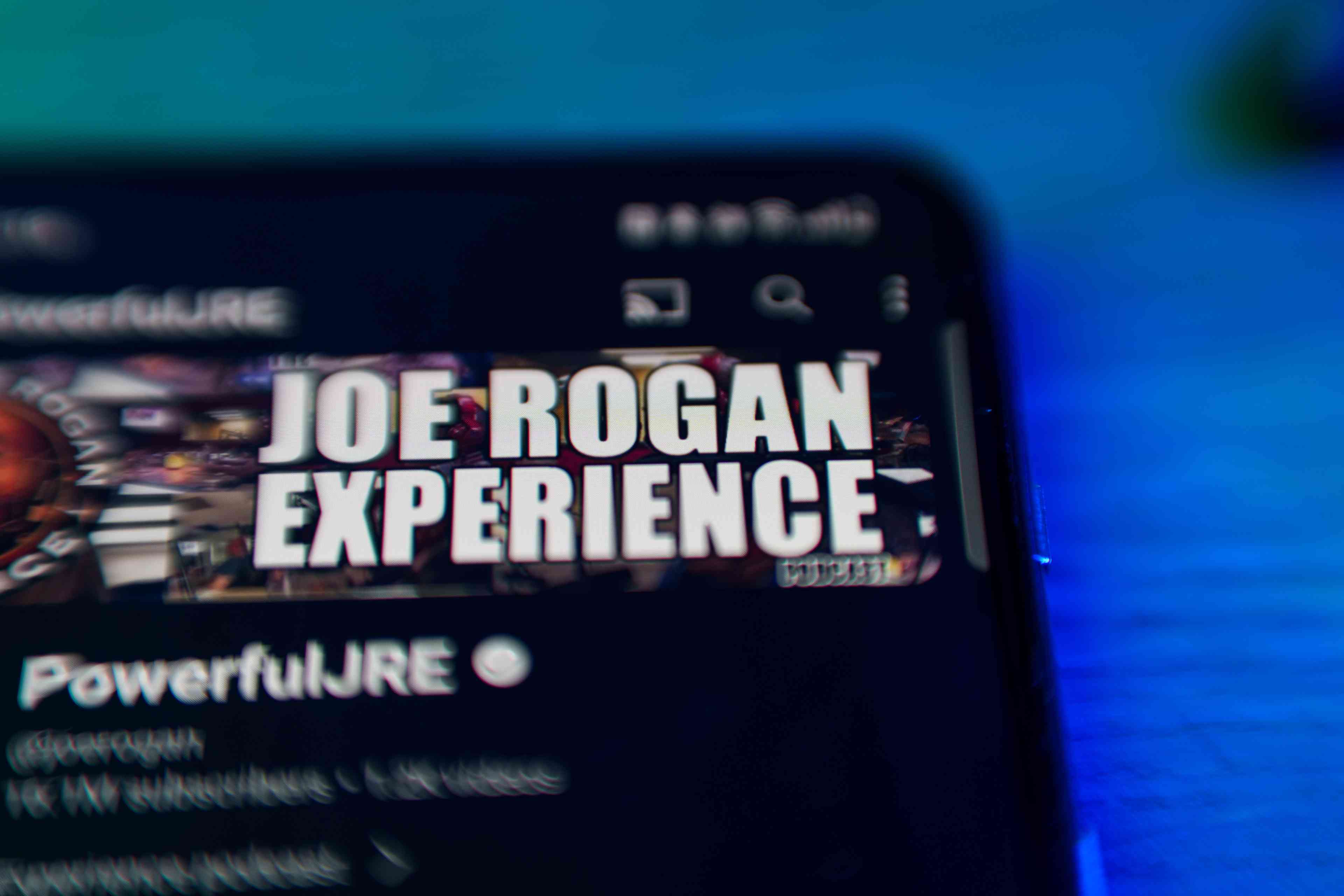 Joe Rogan experience podcast on smartphone screen background