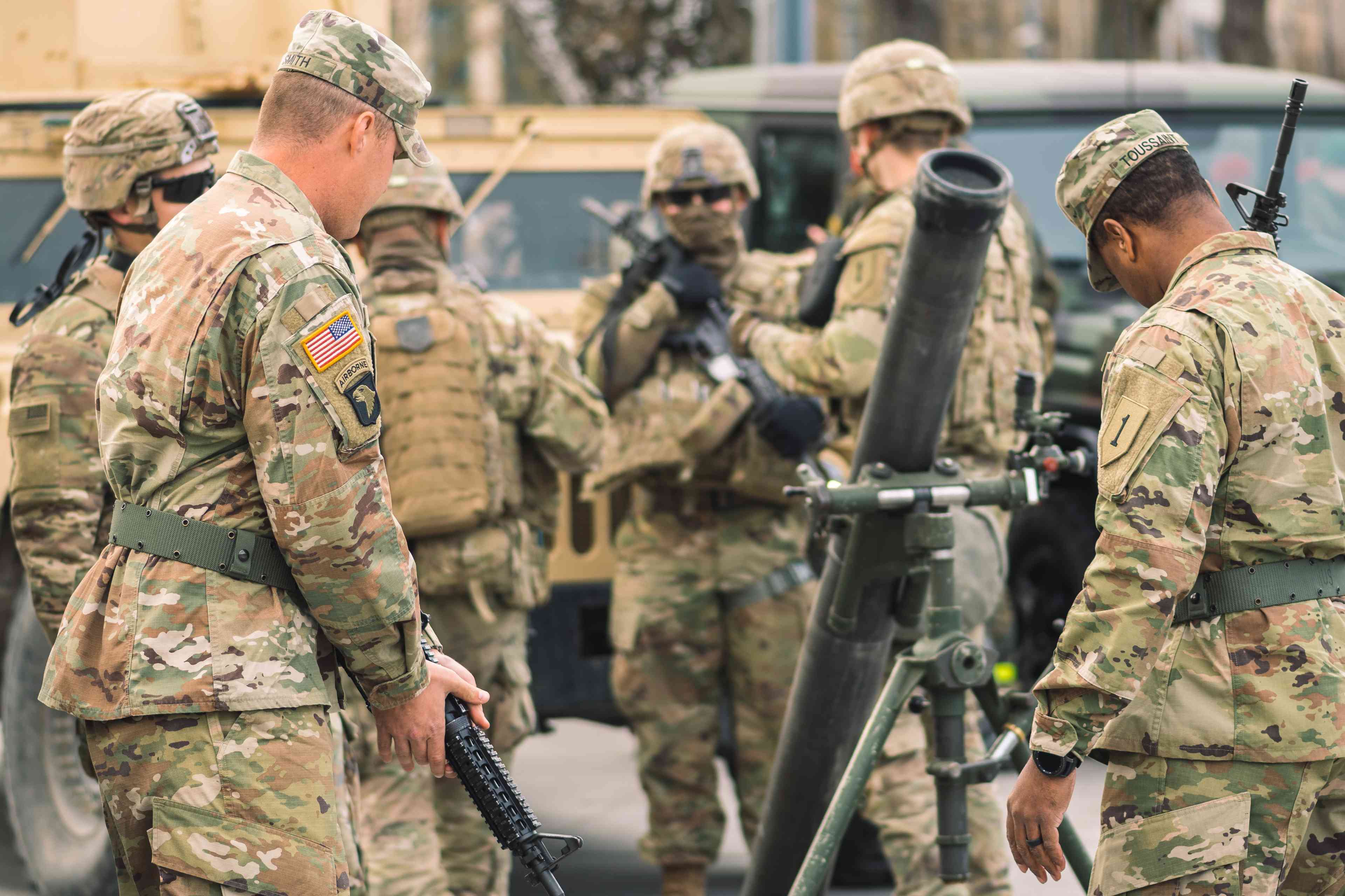 United States Marine Corps soldiers with helmets and shotguns or rifles preparing a mortar background