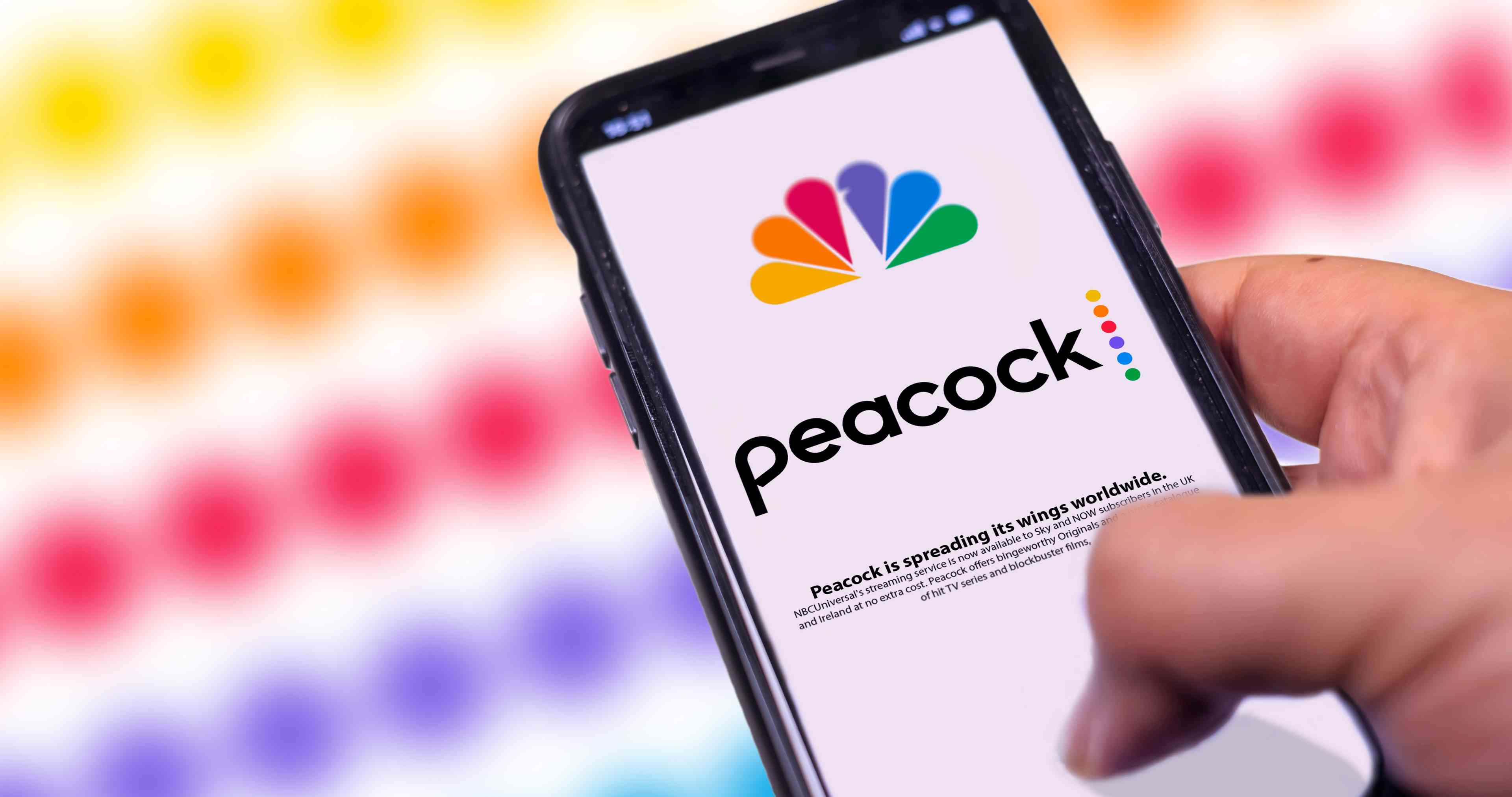Phone with the Peacock Tv mobile app background