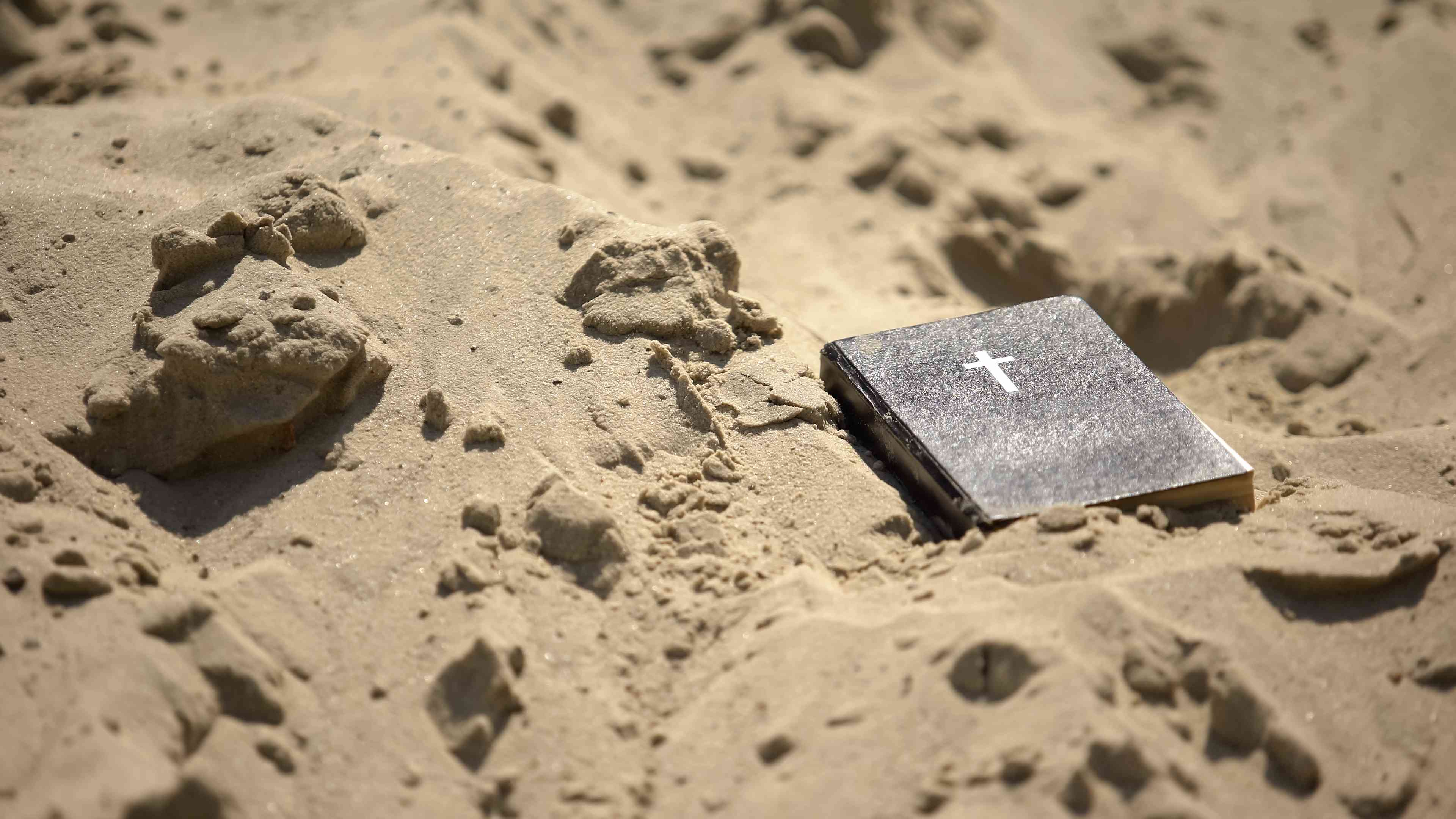 A bible in the sand. background