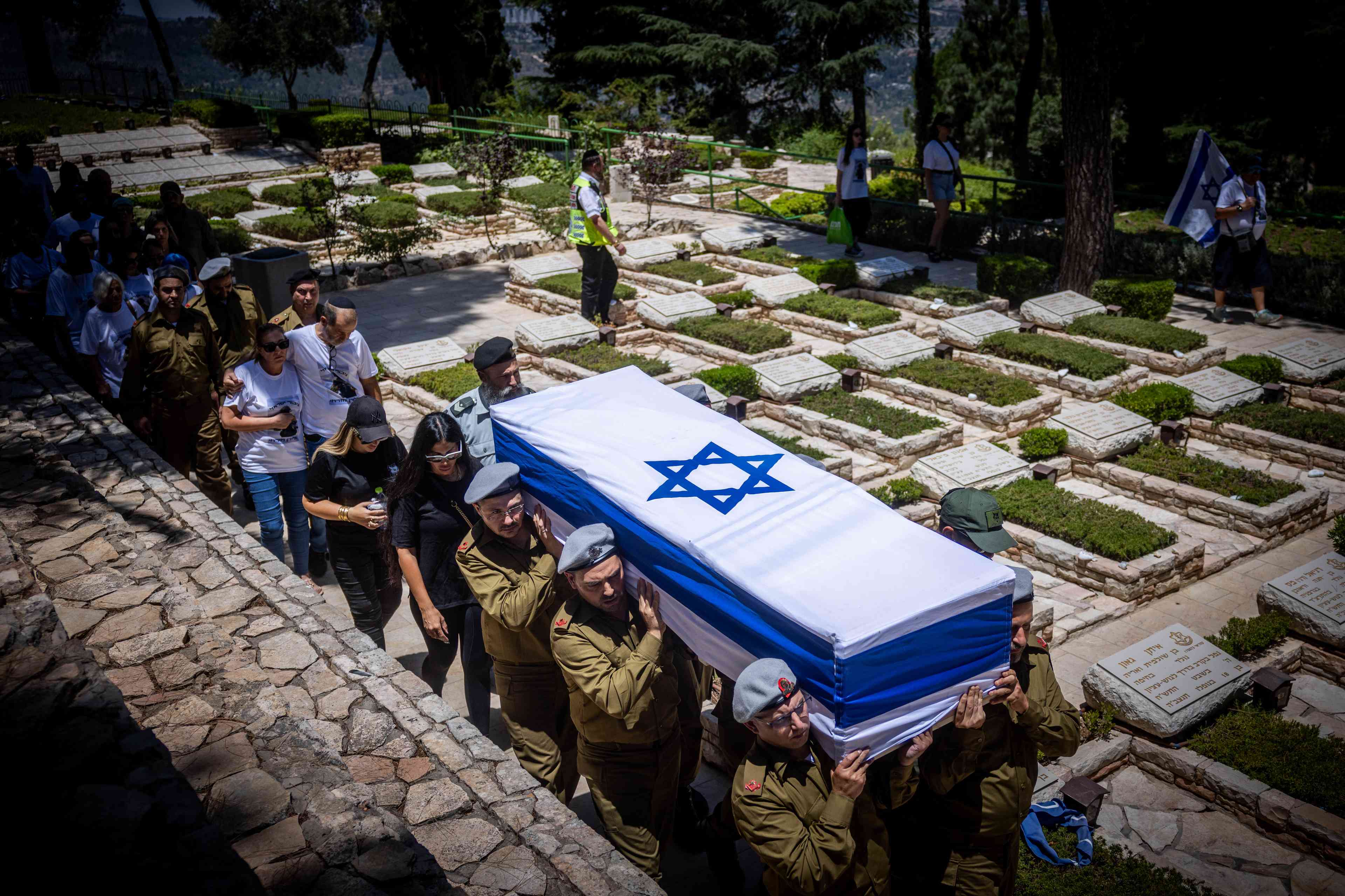Family and friends of Israeli soldier Sgt. Maj. (res.) Eliran MIzrahi attend his funeral at the Mount Herzl Military Cemetery in Jerusalem on June 13, 2024. Mizrahi, a reservist with PTSD, took his life a few days ago. background