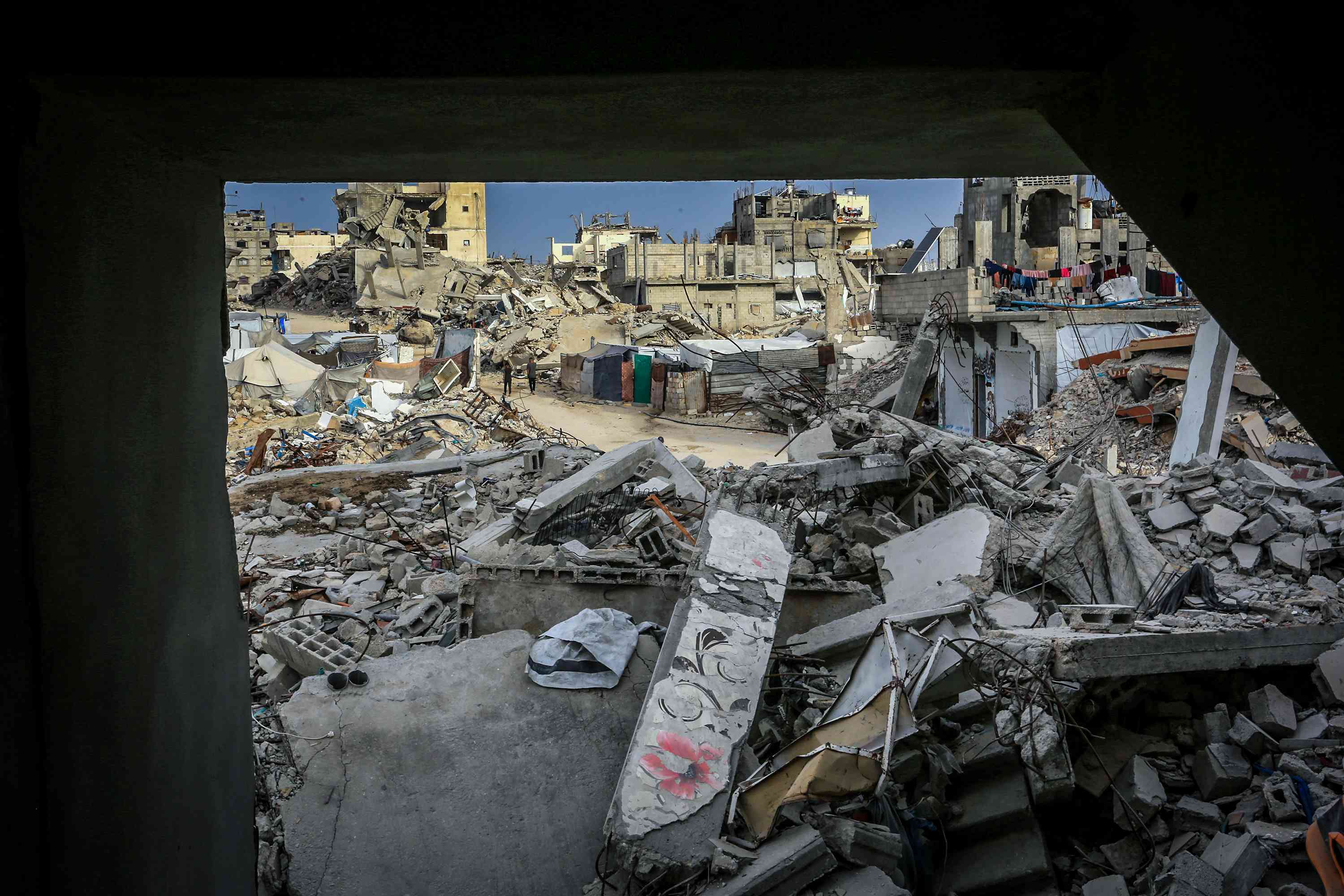 Palestinians inspect the rubble of the Ahmed family's home after it was bombed in an Israeli airstrike background