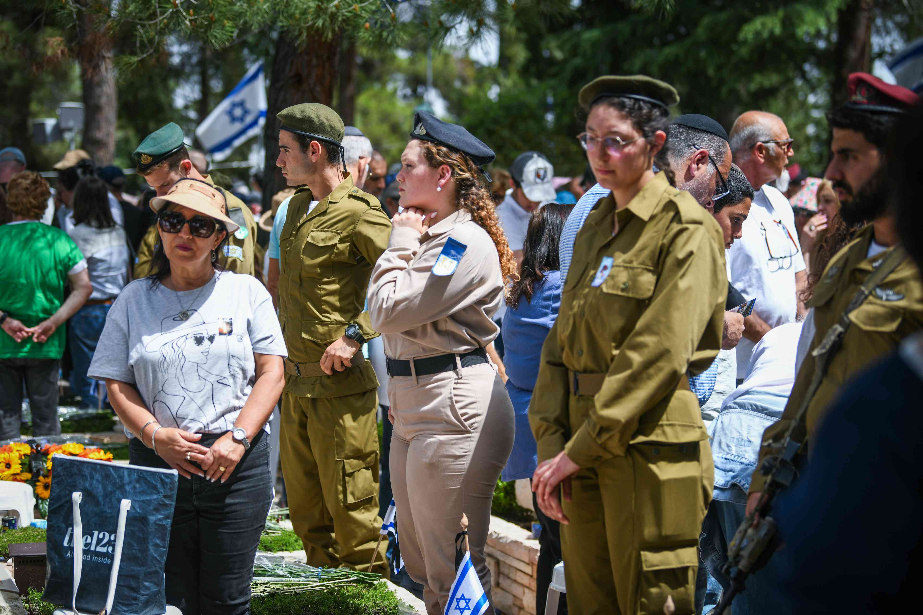 People stand still as a two minutre siren sounded across Israel, marking Memorial Day which commemorates the fallen Israeli soldiers and victims of terror at Mount Herzl Military Cemetery in Jerusalem on April 30, 2025. background