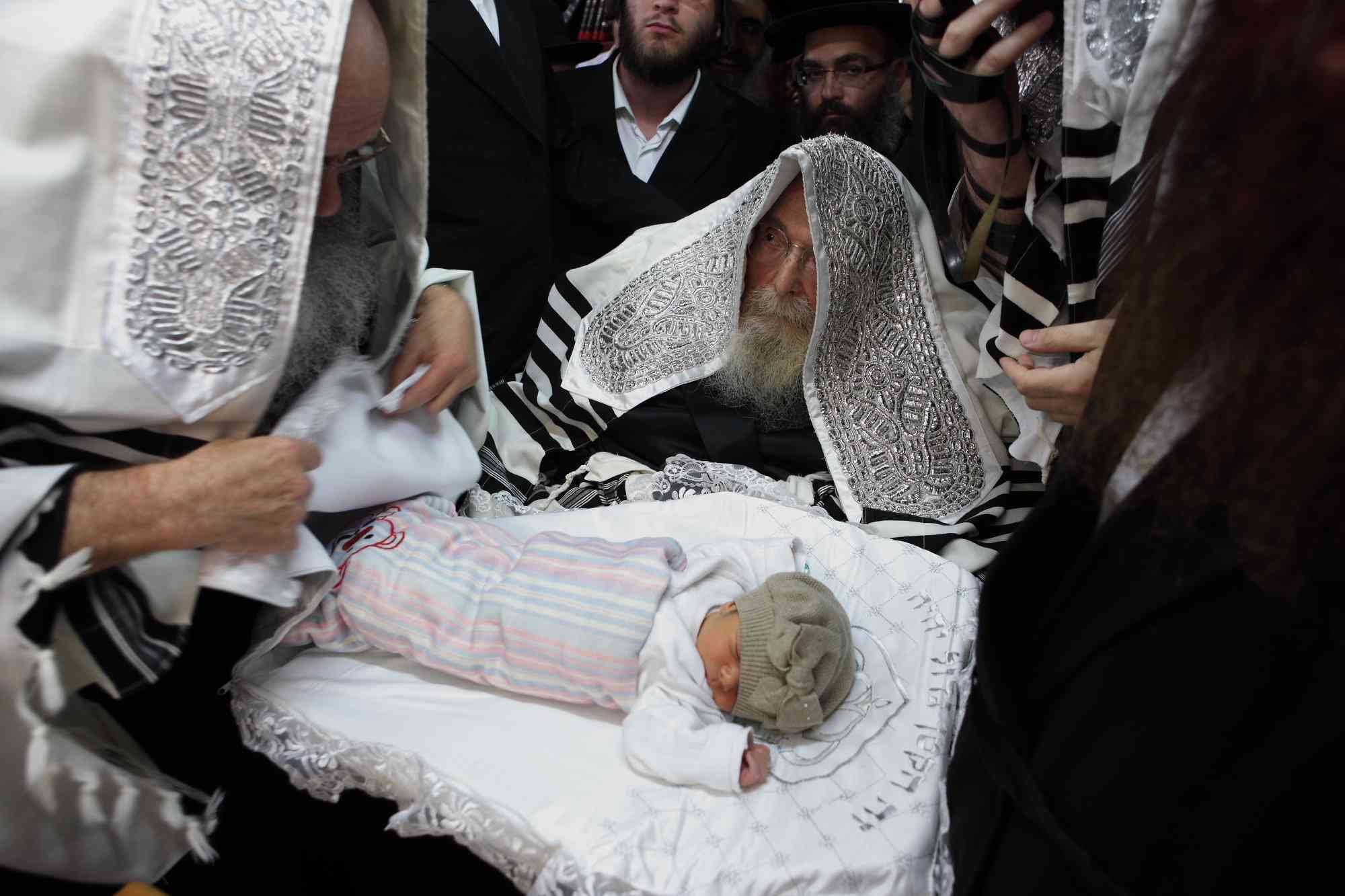 Illustration: The rebbe of Sadigora takes part at a circumcision ceremony in the city of Bnei Brak background