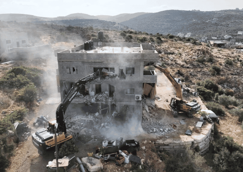 Demolition of building in Bruqin, Samaria background