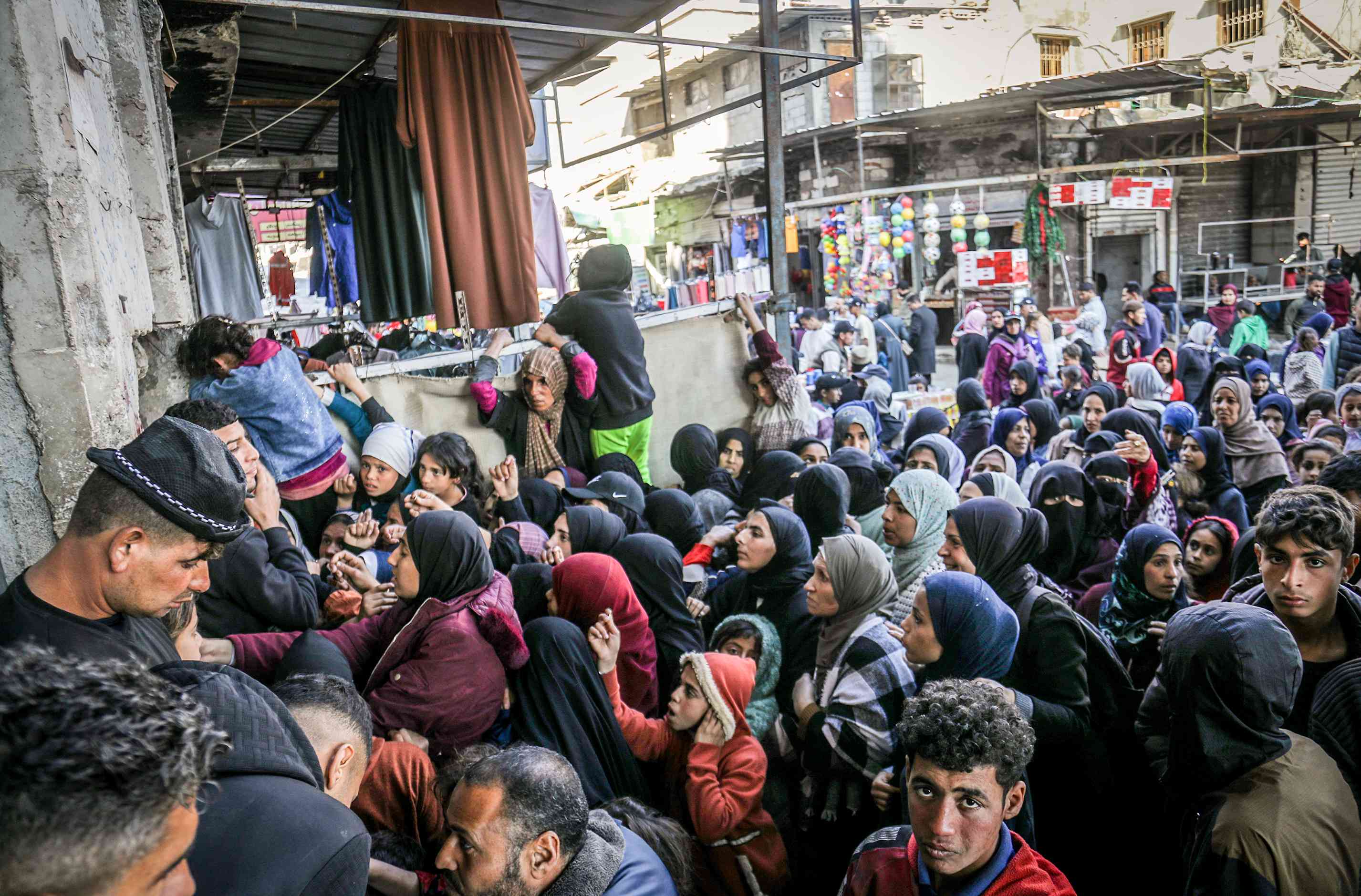 Palestinians crowded into bakeries to obtain a loaf of bread as the crossings remained closed. background