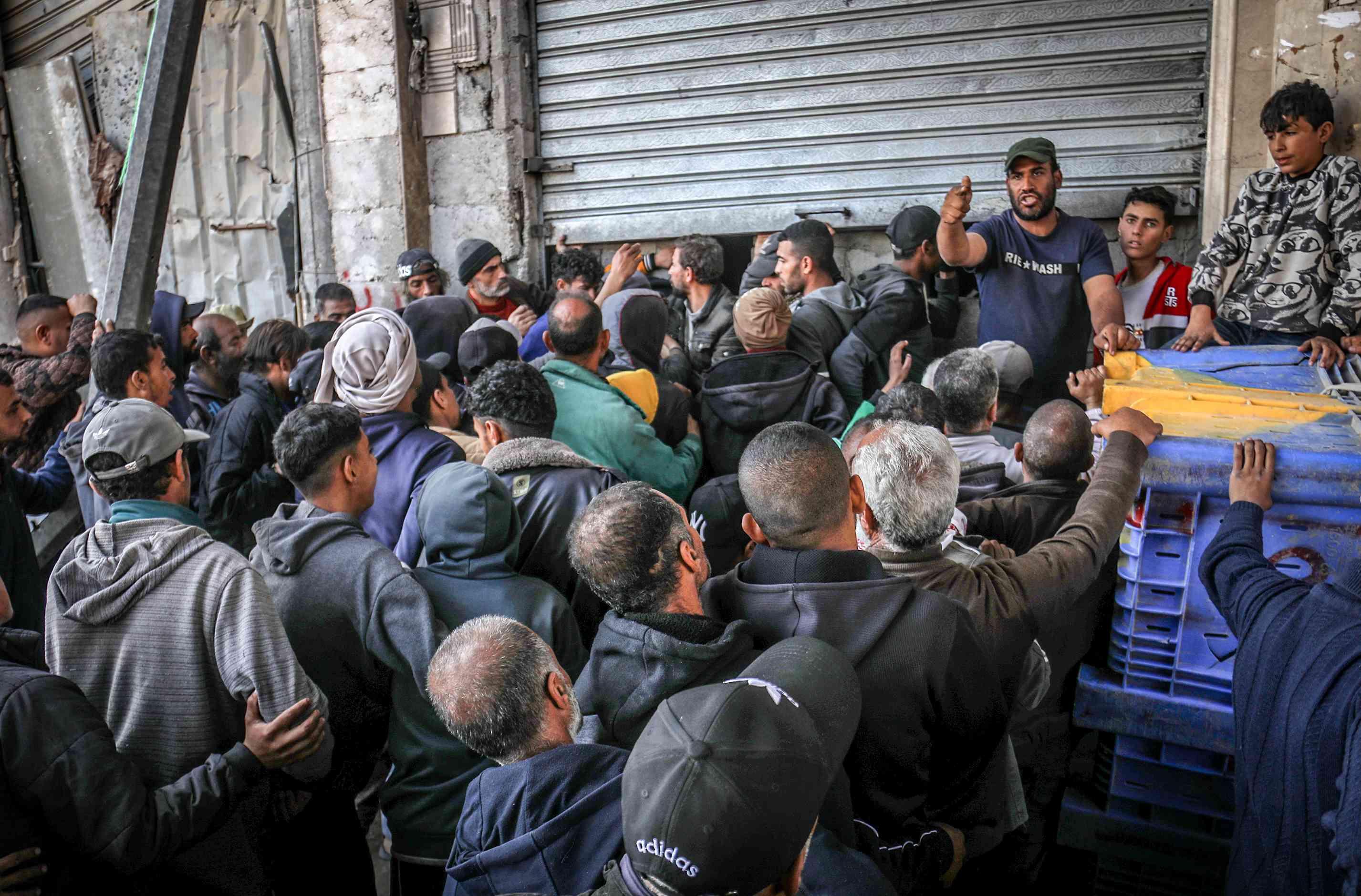Palestinians crowded into bakeries as the crossings remained closed for the third consecutive week, preventing the entry of fuel and humanitarian aid into the Gaza Strip. background