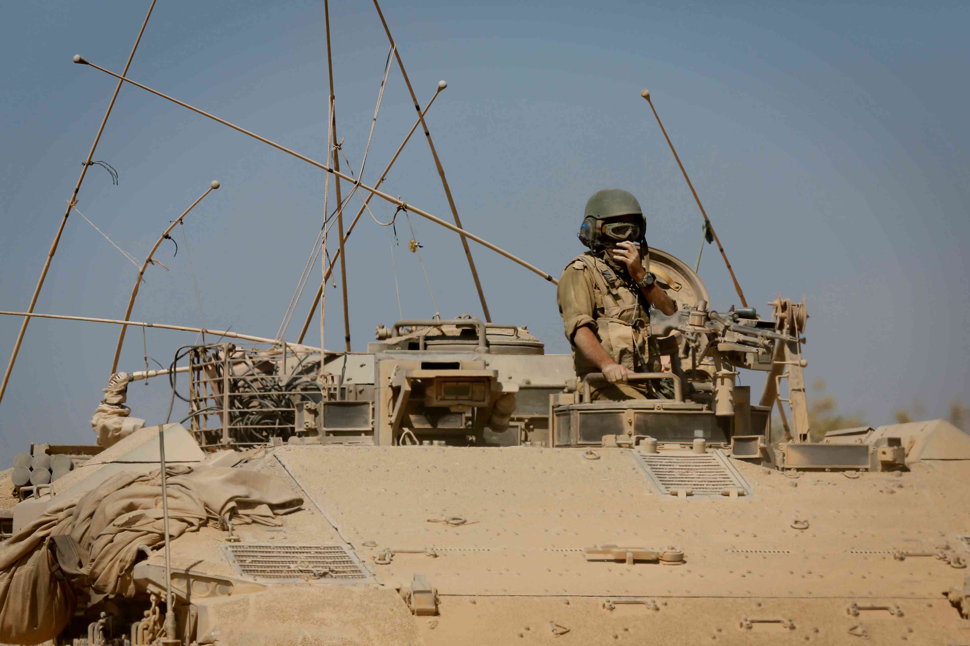 An Israeli soldier seen inside an IDF tank before crossing through a field near the Israeli border with Gaza.  background