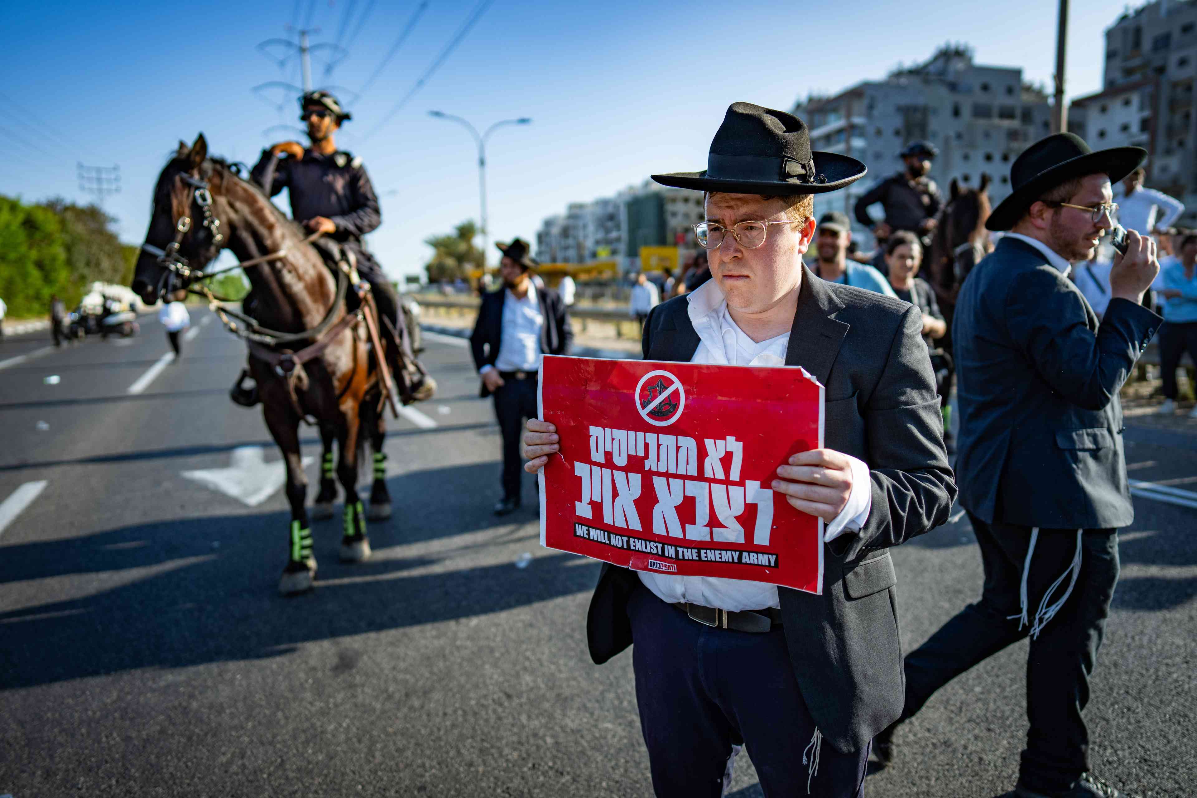 "We won't enlist in the enemy army." Haredi protest against the draft. background