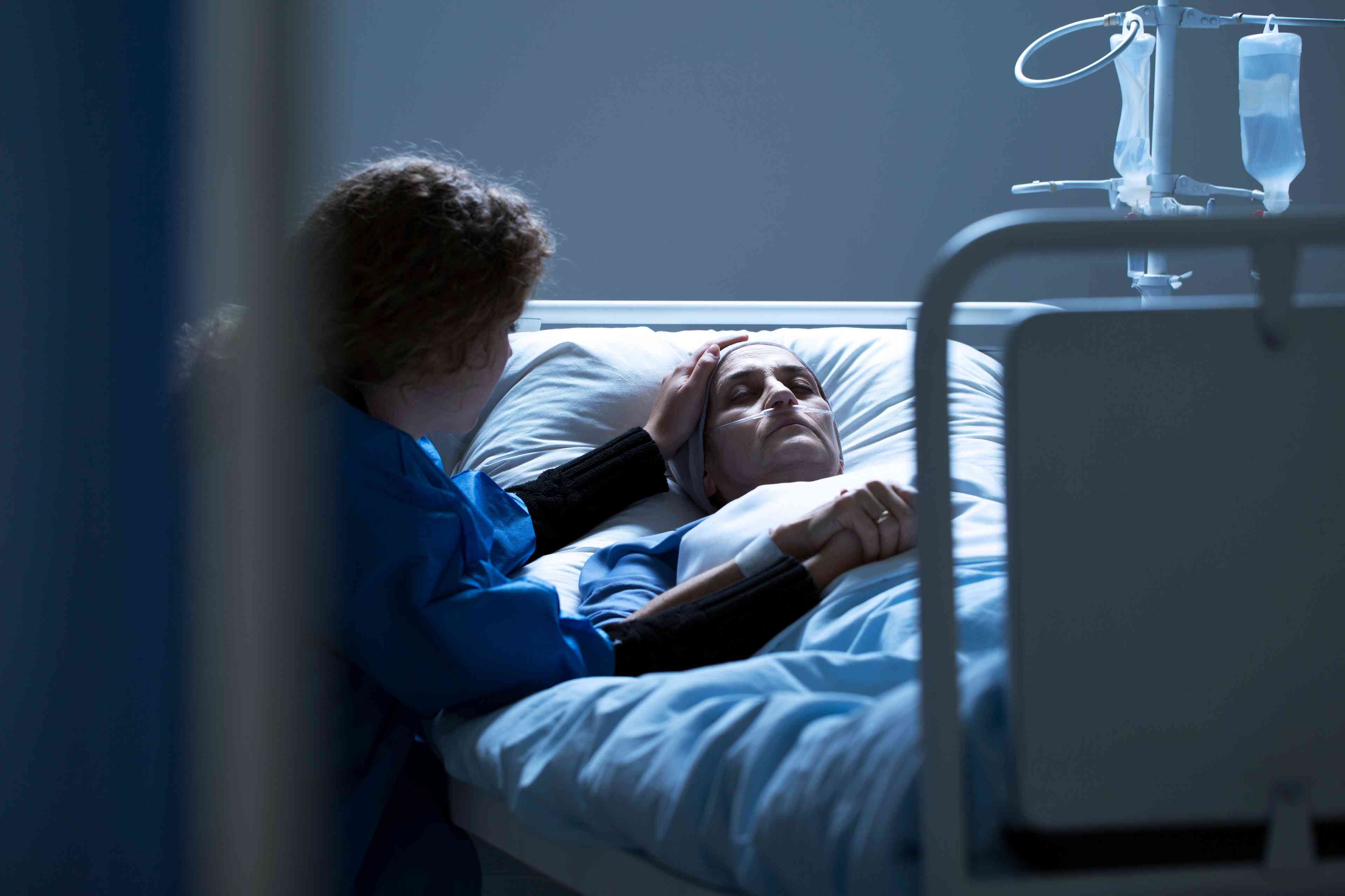 Worried caregiver supporting dying woman with cancer in the hospital   background