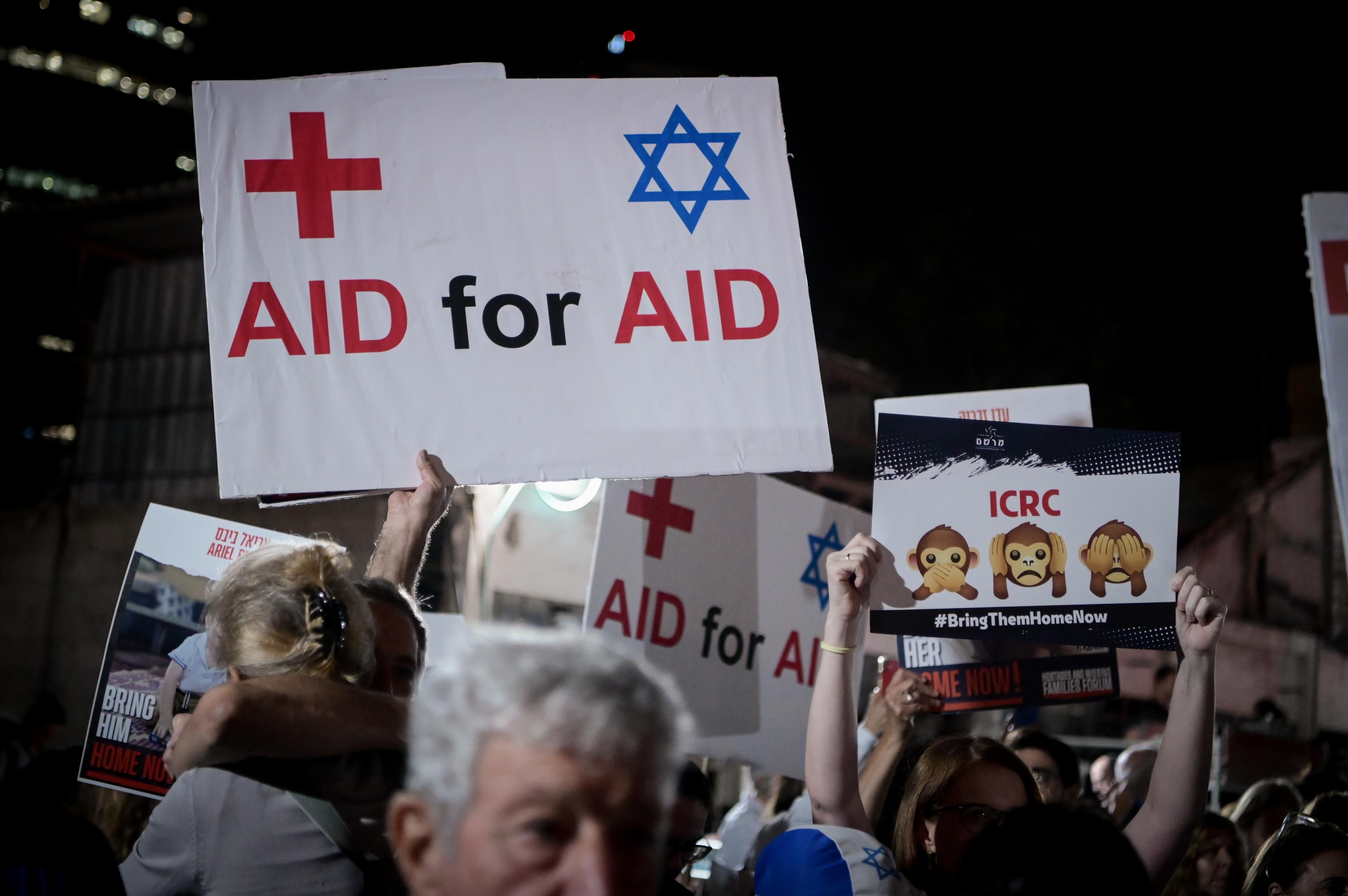 Israeli doctors hold photographs of the kidnapped people held hostage by Hamas terrorists in Gaza, as they protest outside the Red Cross headquarters in Tel Aviv, November 9, 2023.