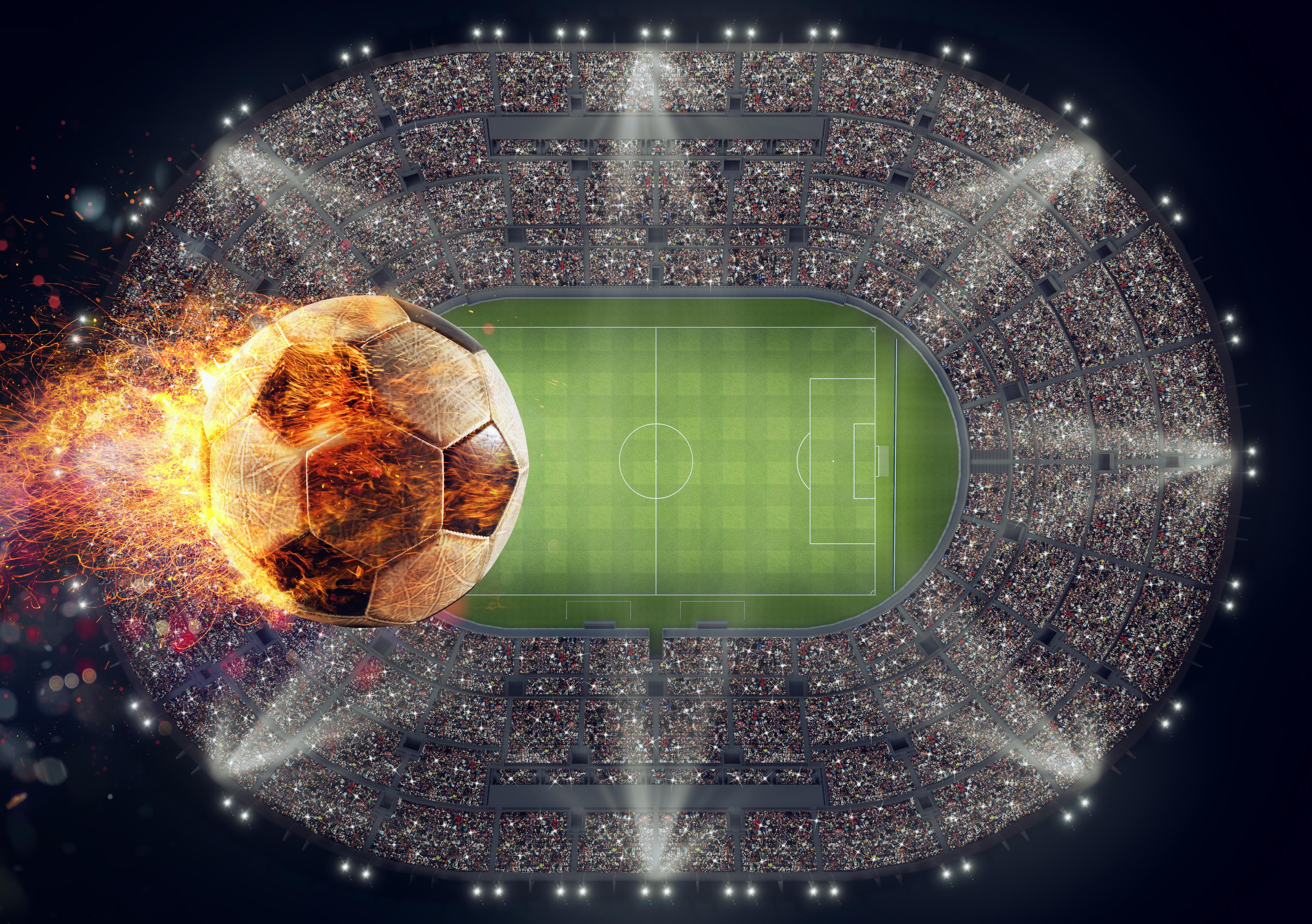 Soccer ball with flame of fire over a stadium