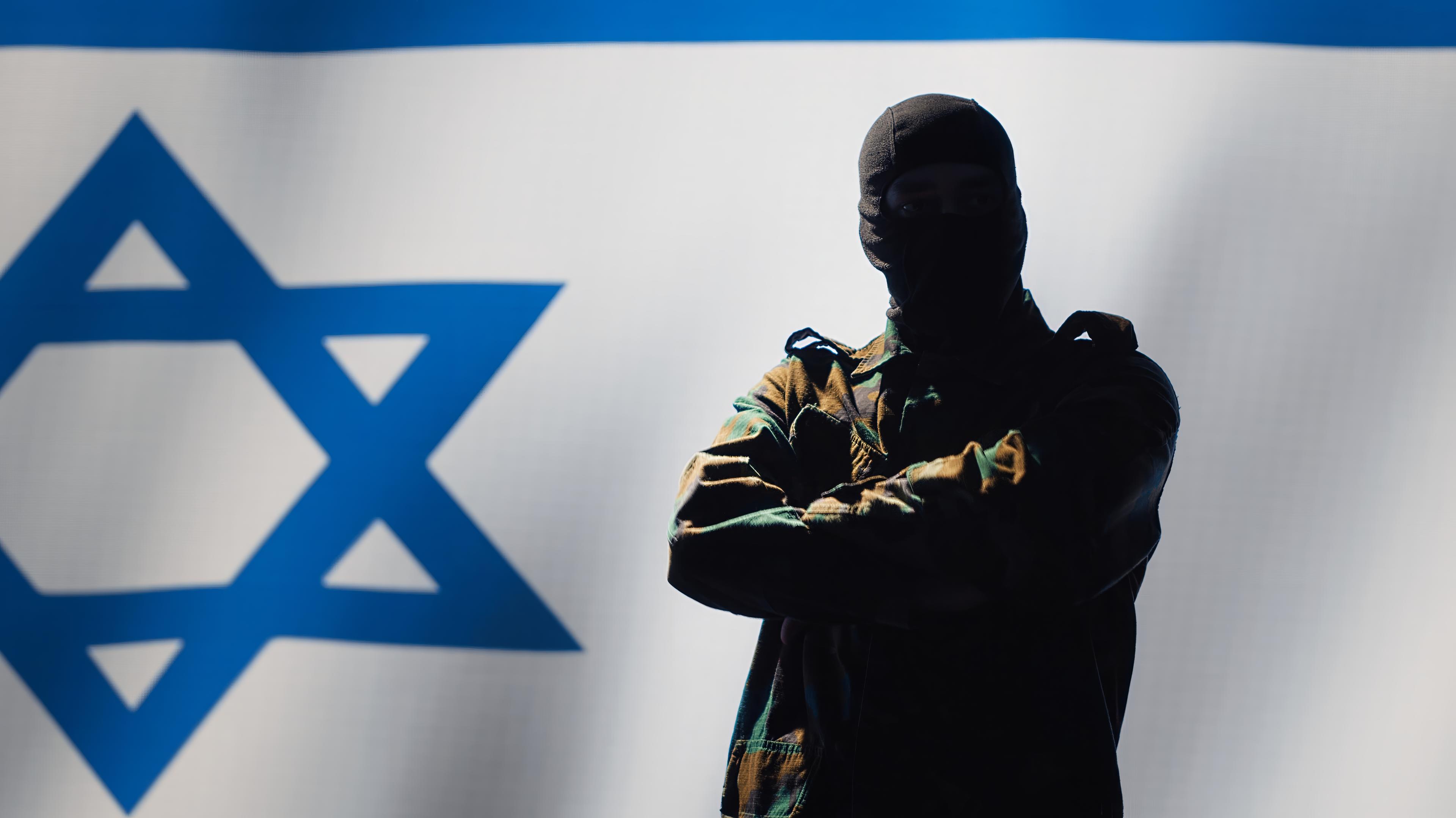Mossad agent standing proud in front of Israel flag Mossad agent standing proud in front of Israel flag