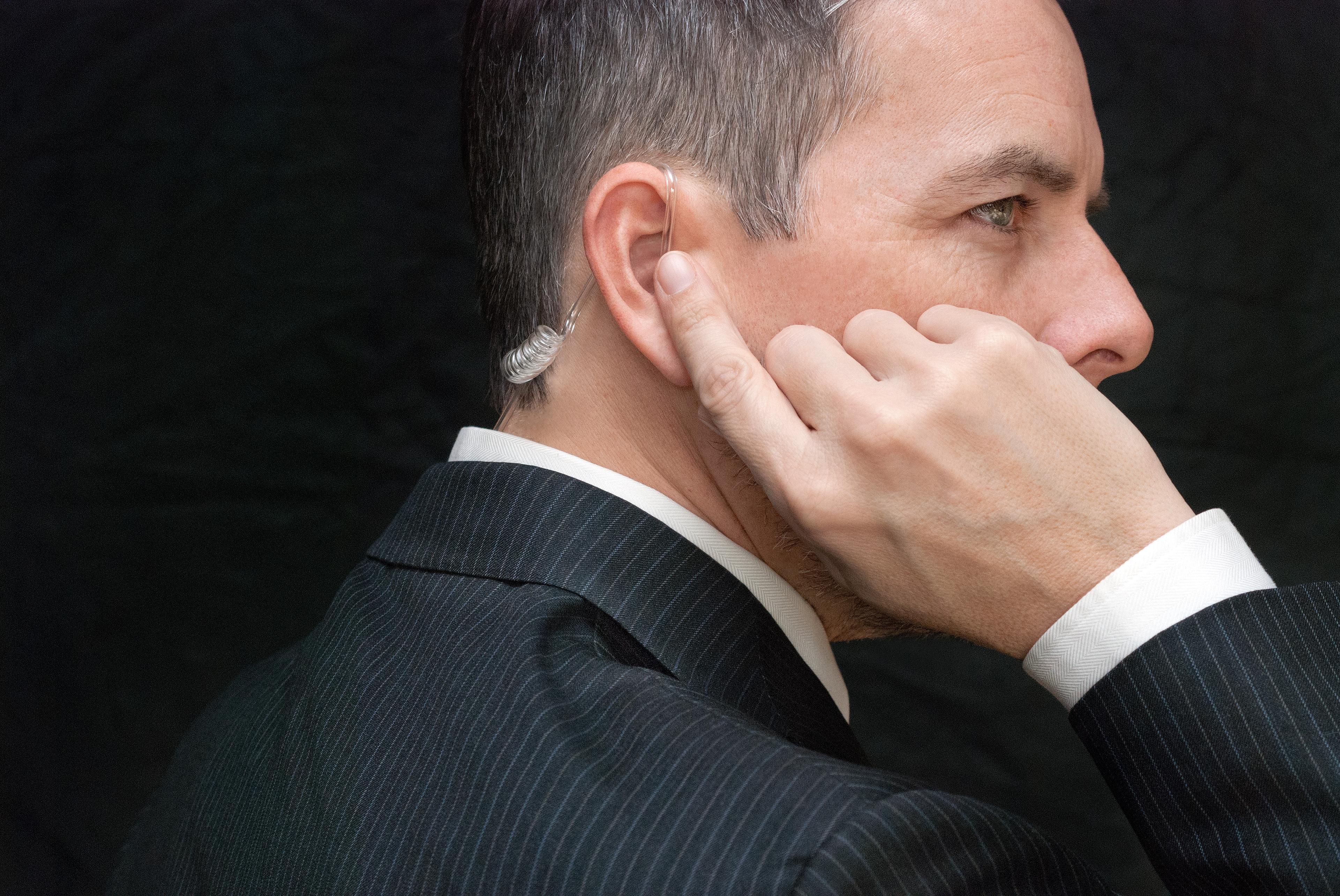 Close-up of a secret service agent listening to his earpiece