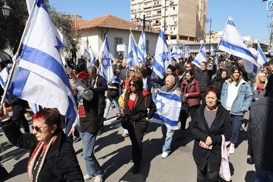 Mourners carrying Israeli flags