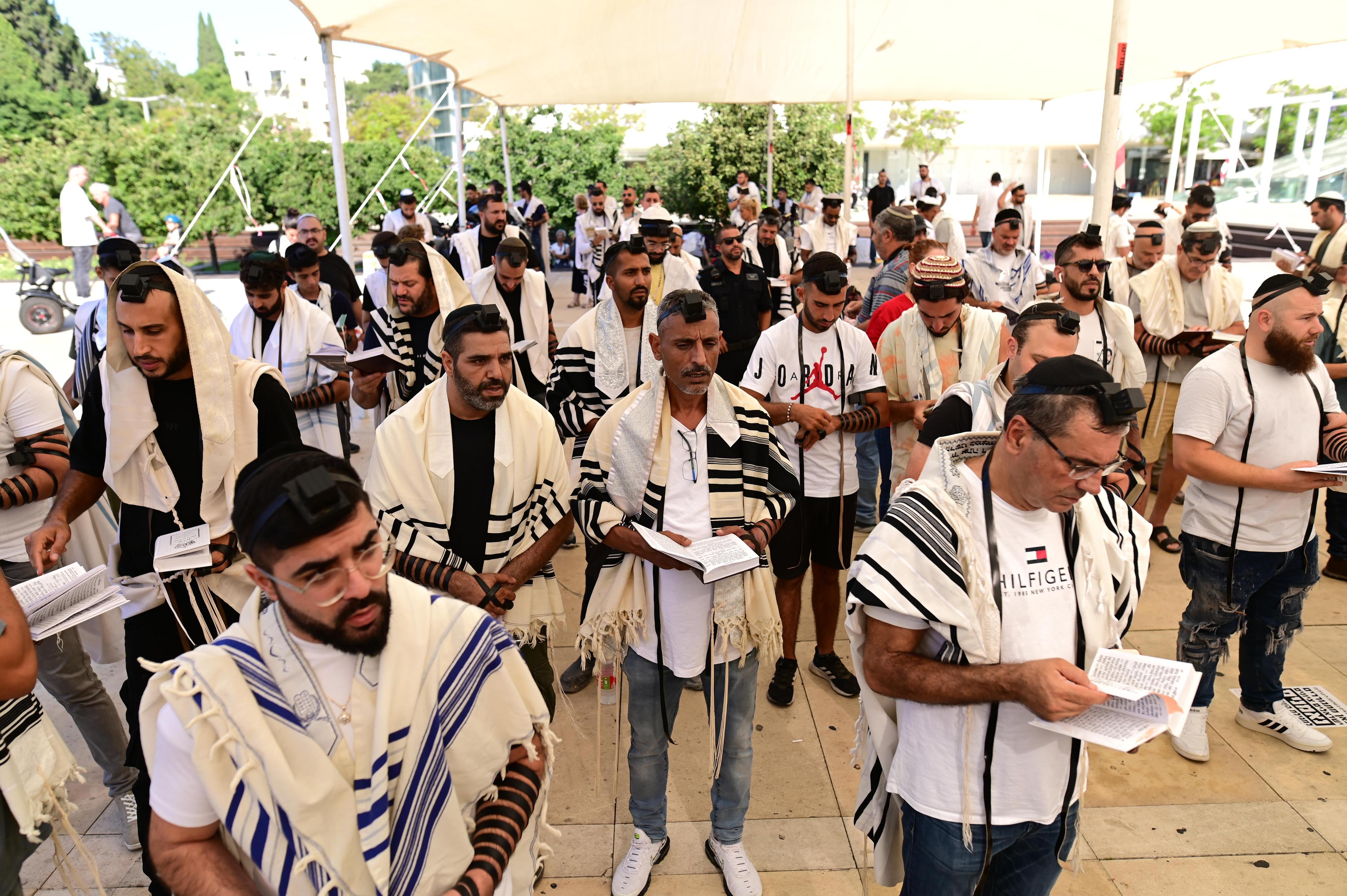 Jewish men with Tefillin and prayer shawls take part in a mass prayer as they mark the "International Day of Tefillin" at Habima Square in Tel Aviv, August 2, 2023