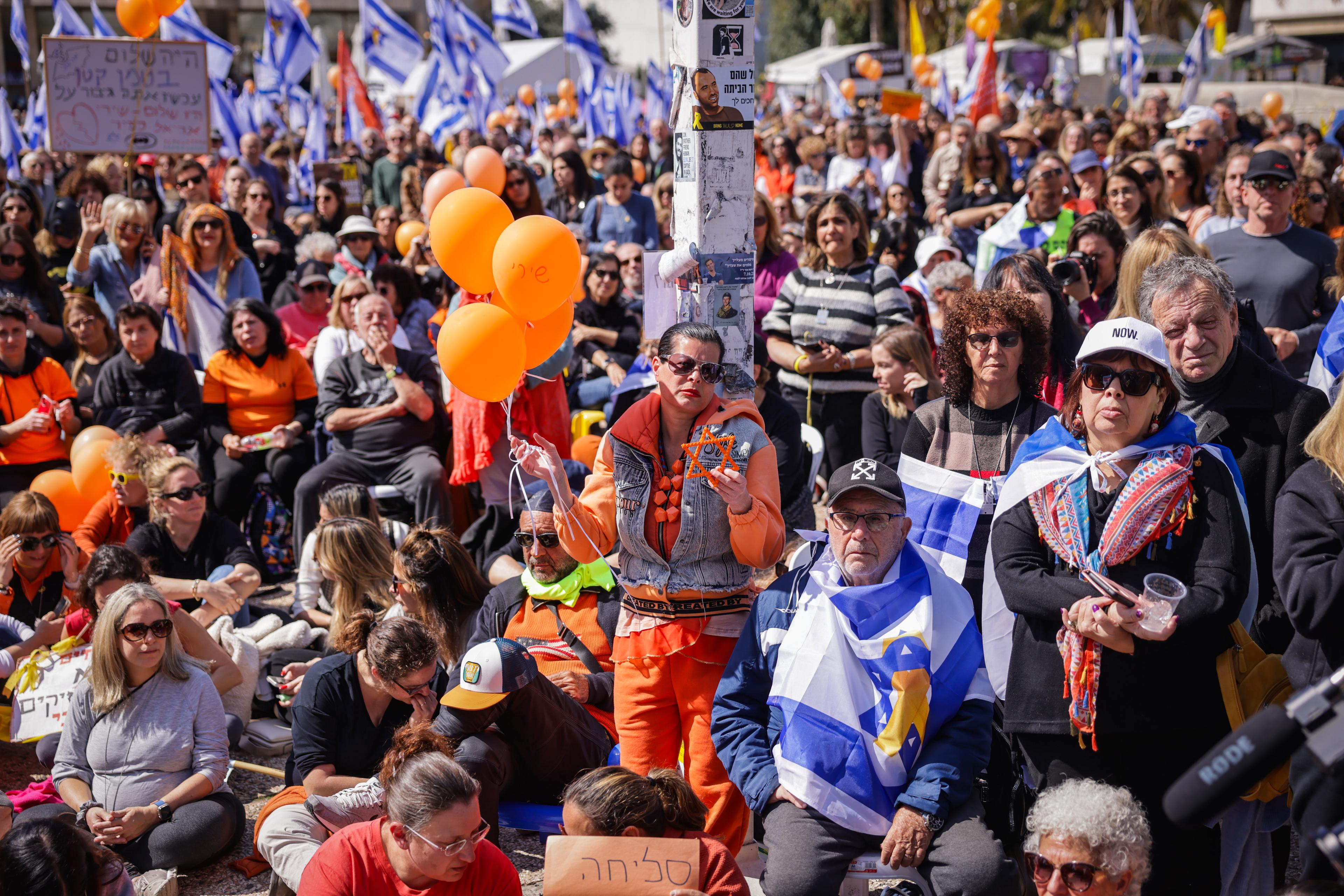 People gather to pay their respects during the funeral service of late Israeli hostages Shiri Bibas and her children Ariel and Kfir, at "Hostage Square" in Tel Aviv, February 26, 2025. 