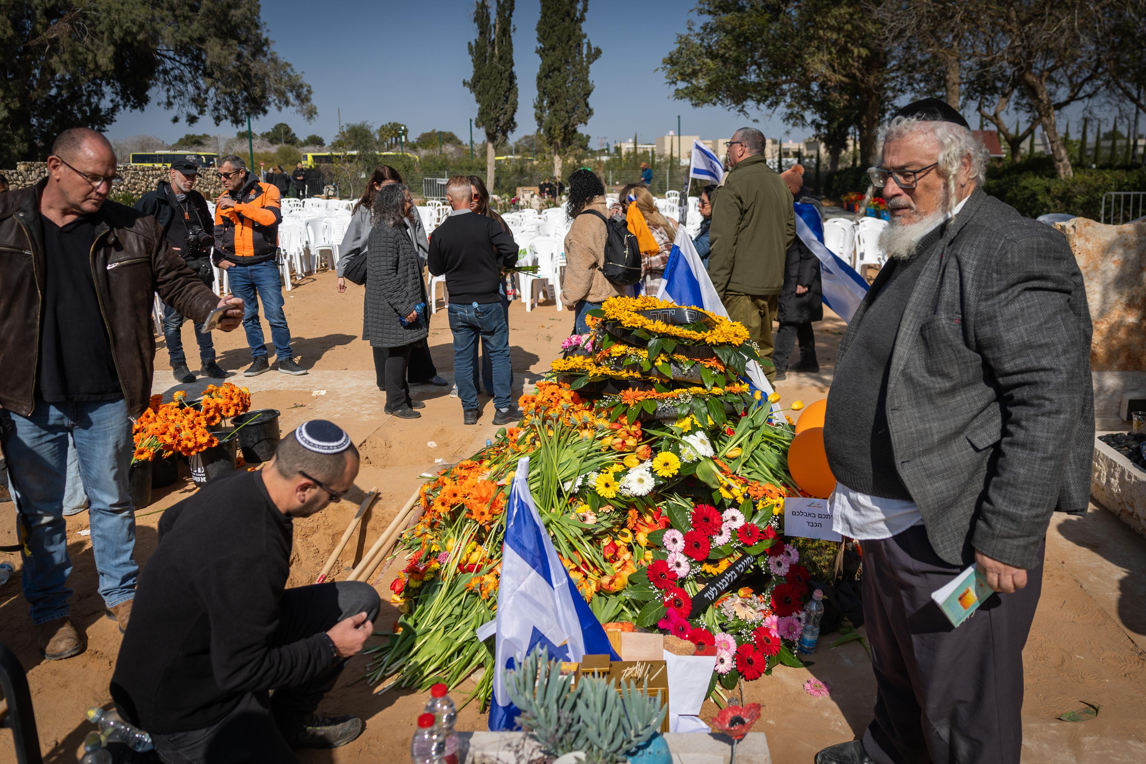 Mourners near the fresh grave of late Israeli hostages Shiri Bibas and her children Ariel and Kfir at the cemetery in Tzohar, southern Israel, February 26, 2025.