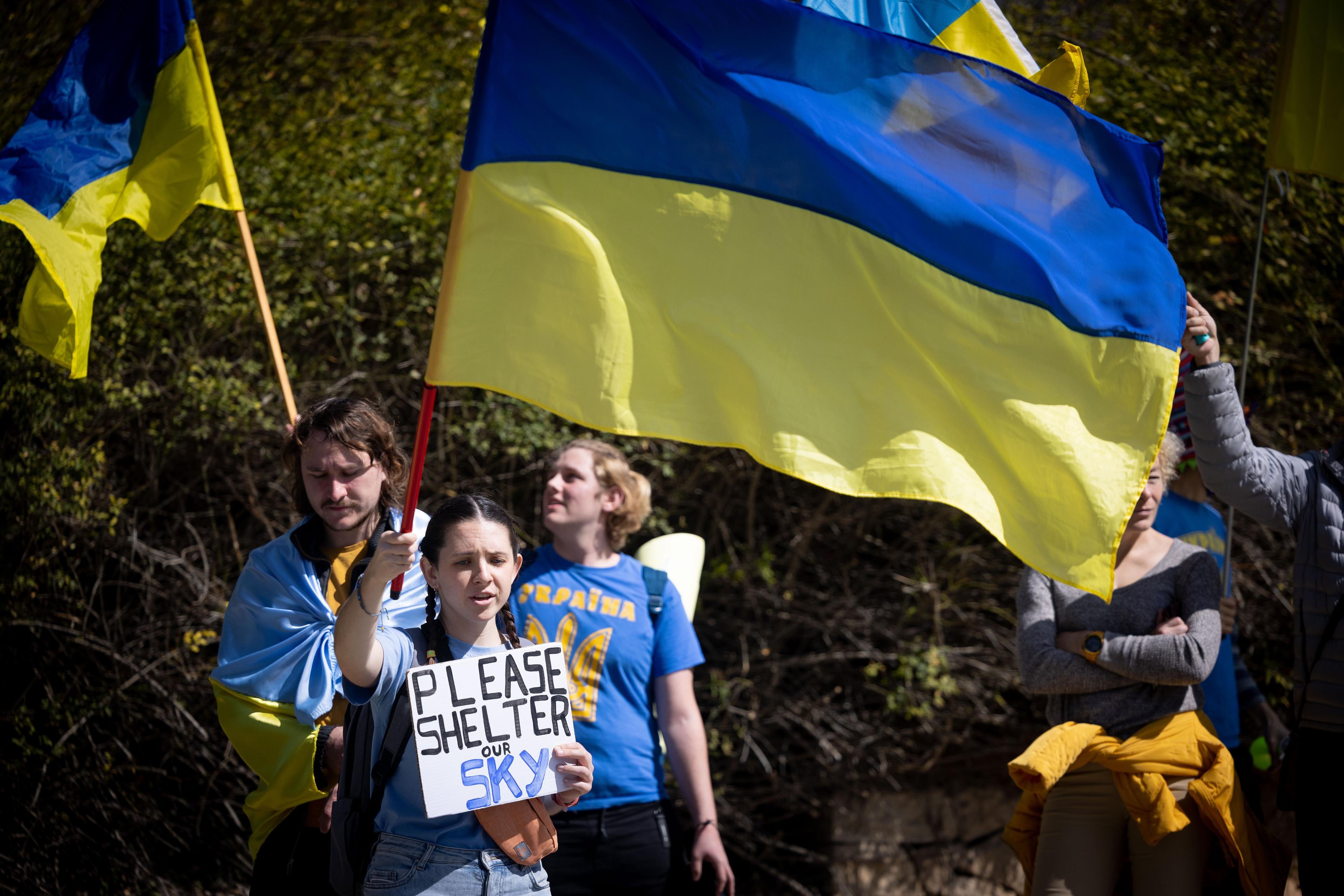 Demonstrators carry placards and flags during a protest march against the Russian invasion in Ukraine