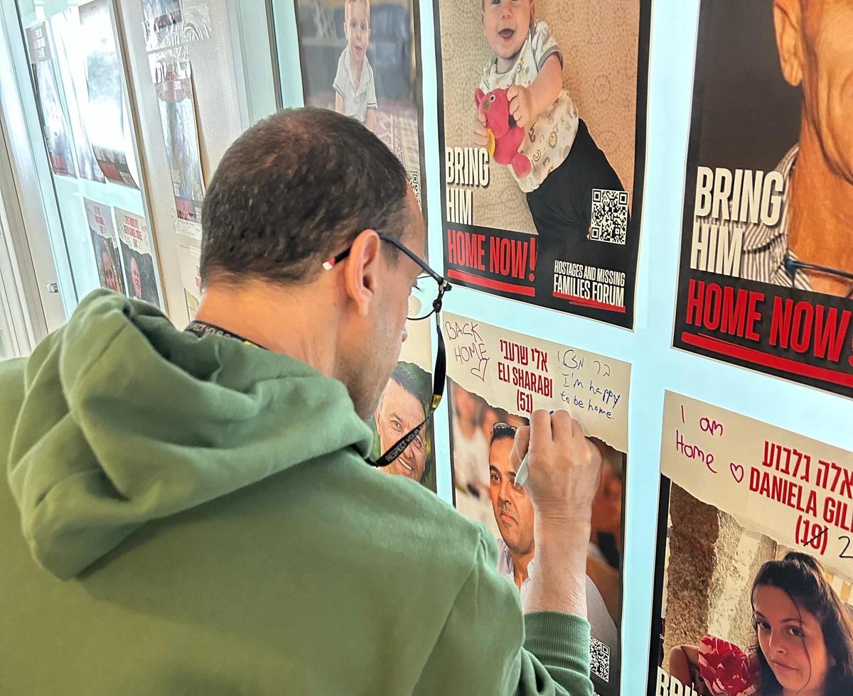 Eli Sharabi writing on his hostage poster