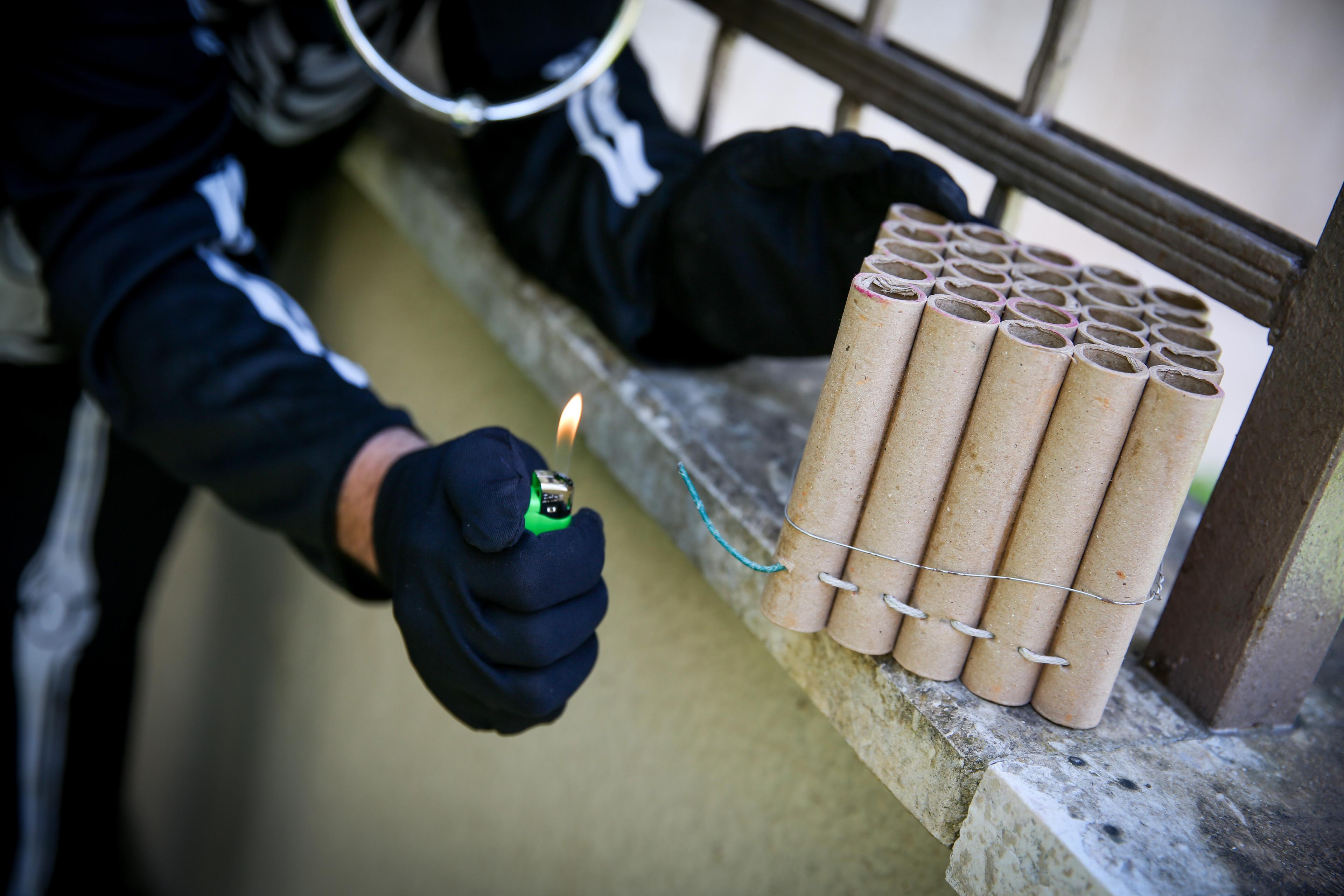 man lighting firecrackers, ahead of Purim, in the Northern Israeli city of Tzfat
