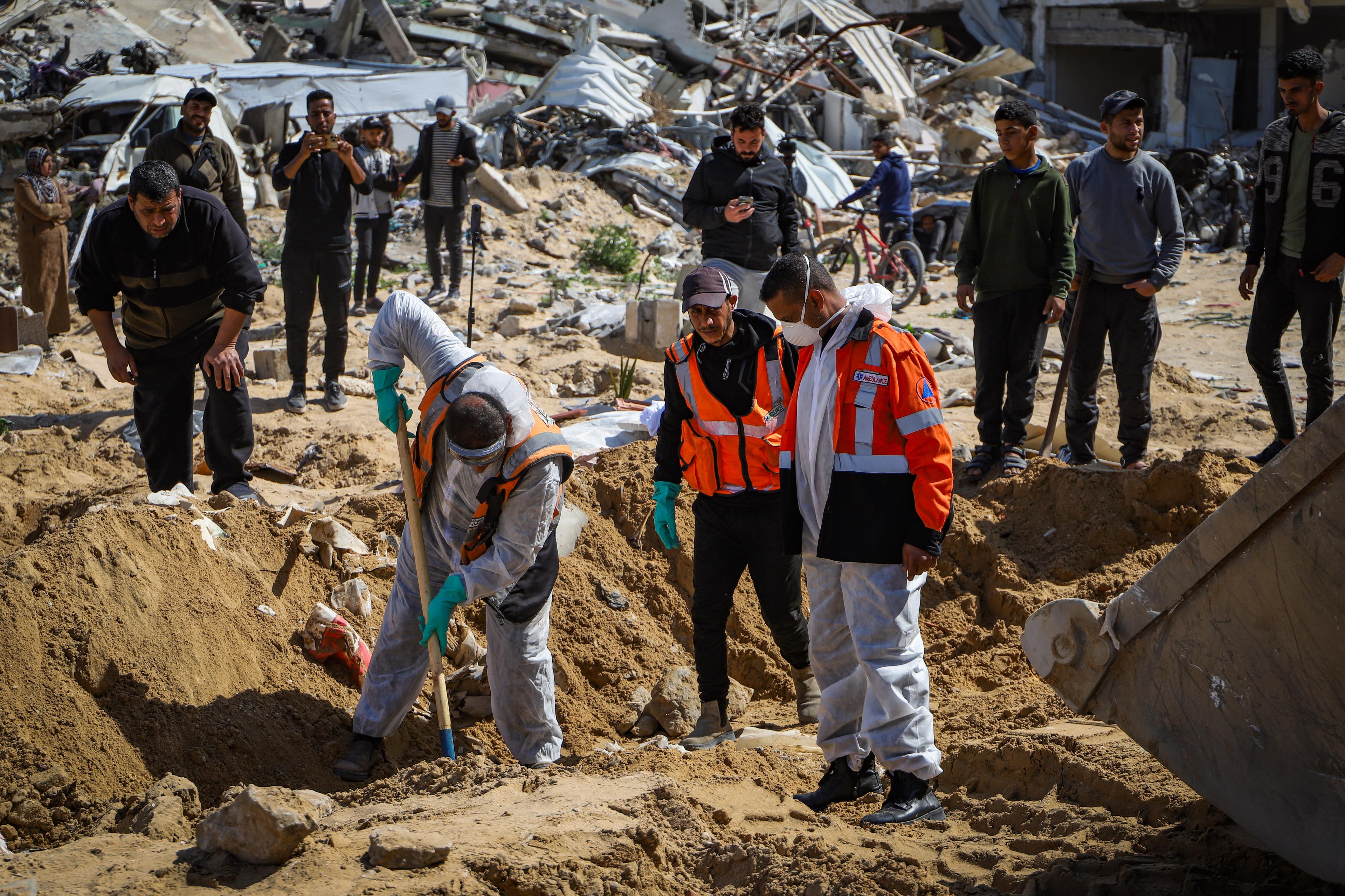 Civil defense crews recover bodies from a mass grave, outside the Al-Shifa Hospital, west of Gaza City, on March 13, 2025. 