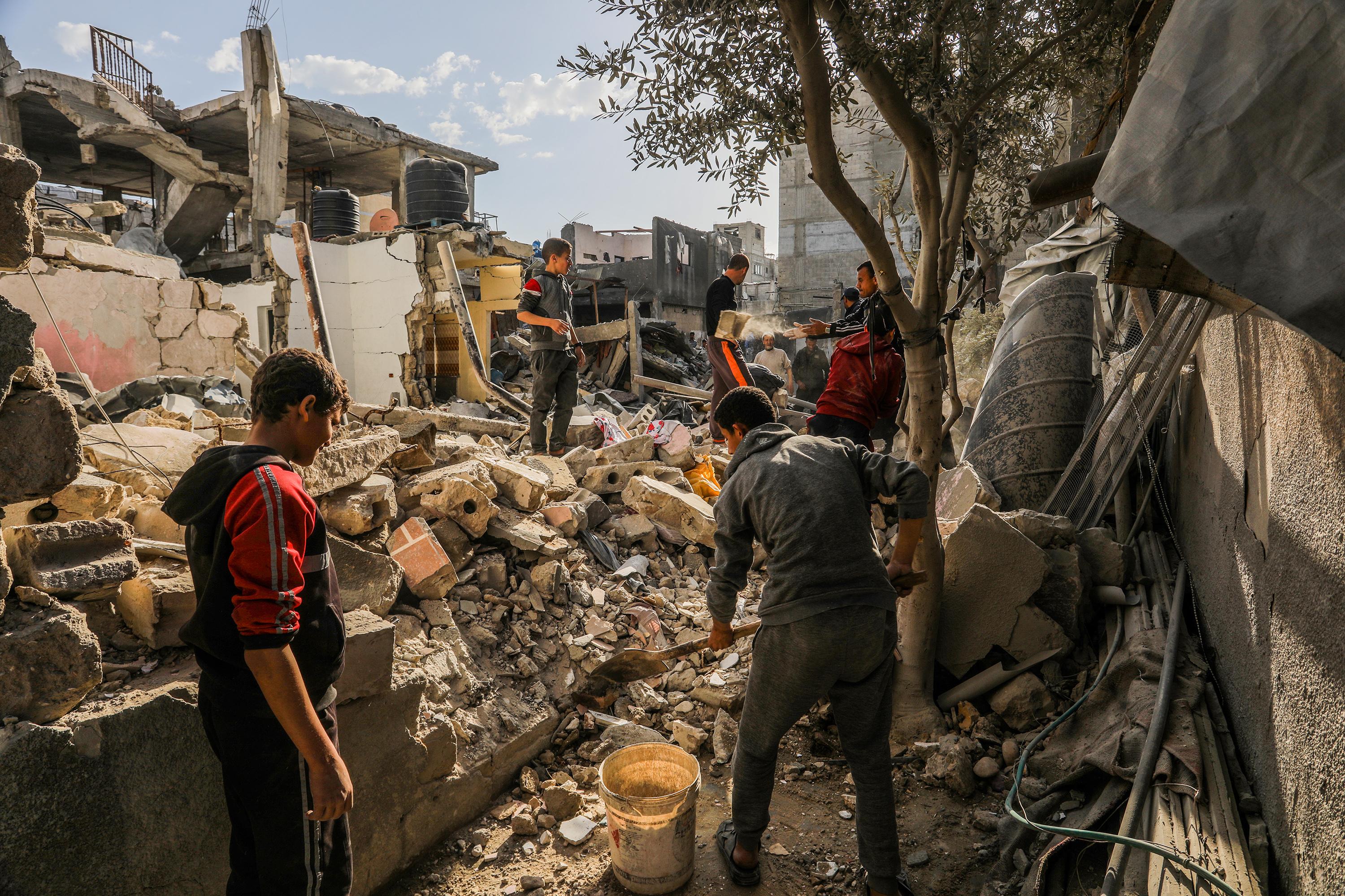 Palestinians at the scene of an Israeli airstrike in Khan Yunis, on March 18, 2025