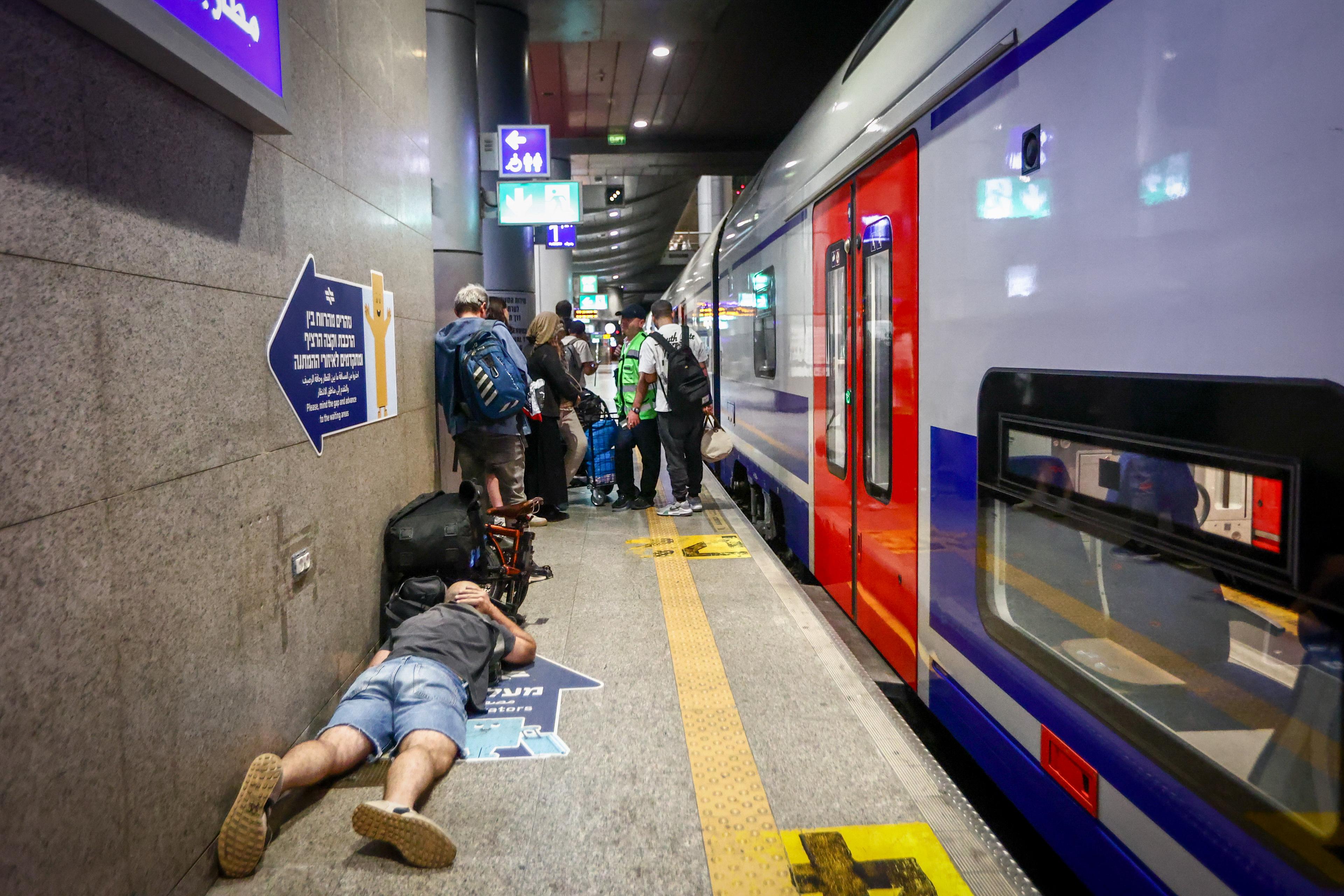 Israelis take cover inside a bomb shelter at the Ben Gurion airport as a siren alert is sounded in Tel Aviv