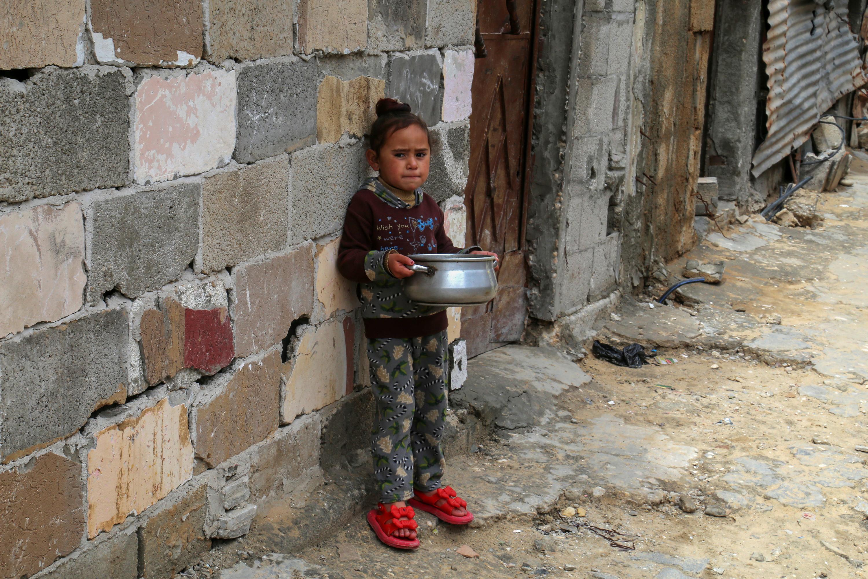 Palestinians receive meals from the World Kitchen in Khan Yunis, on March 22, 2025. 
