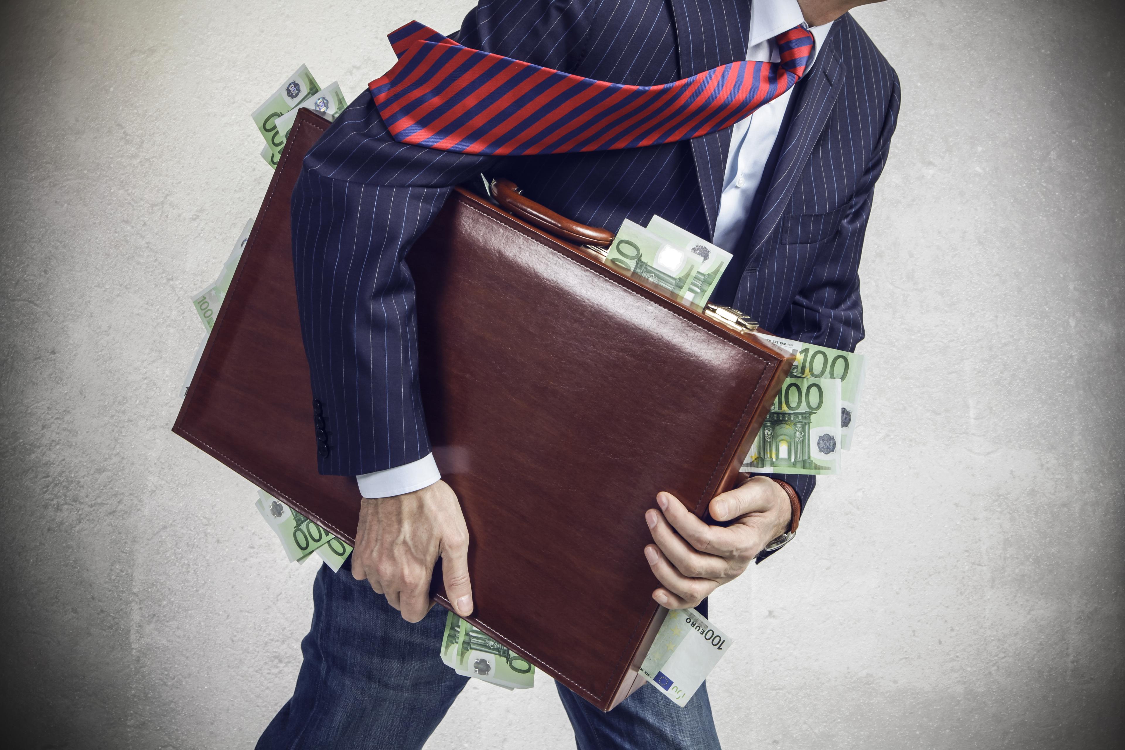 Man carrying suitcase filled with cash