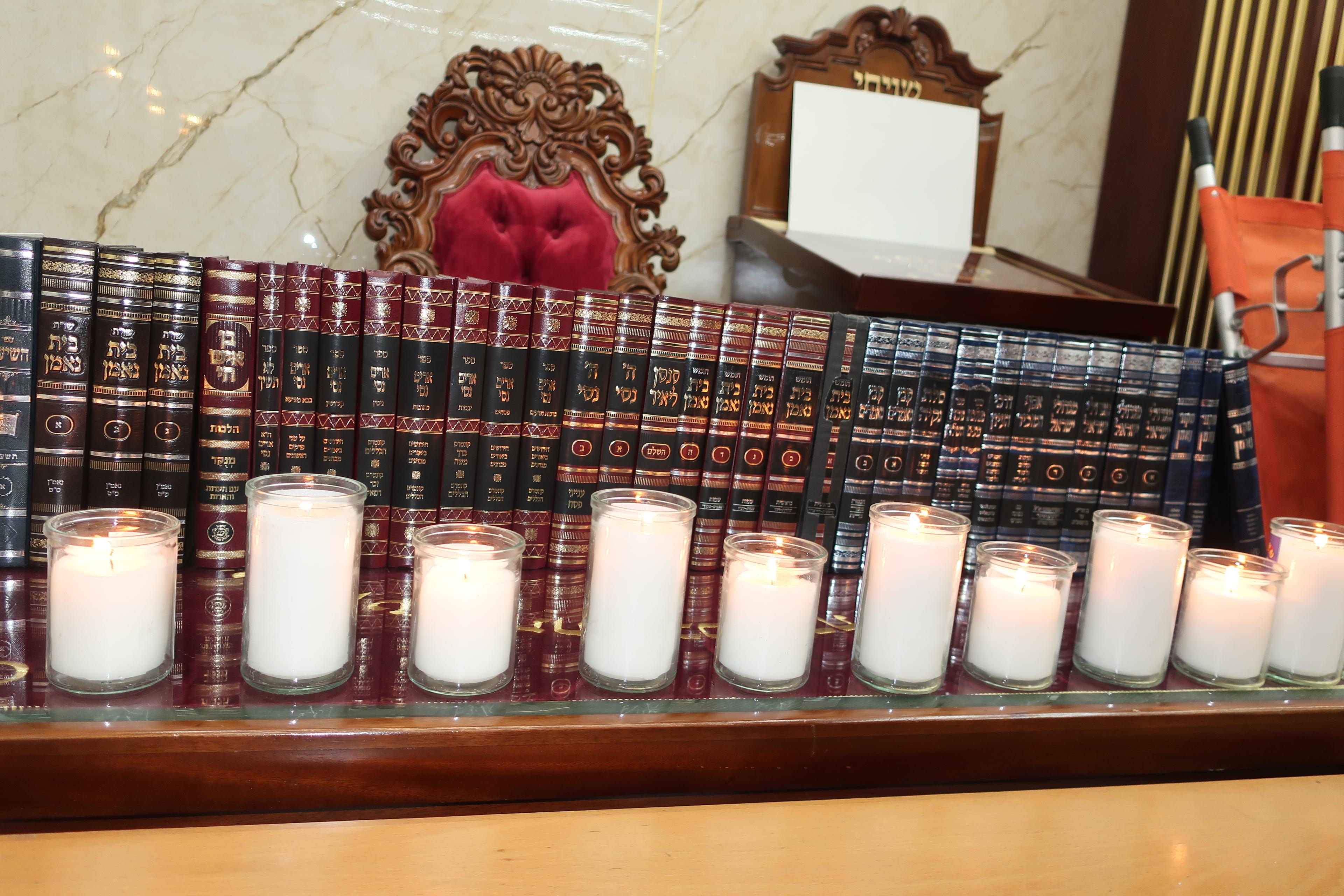 Memorial candles next to seforim published by Rabbi Mazuz ztz"l