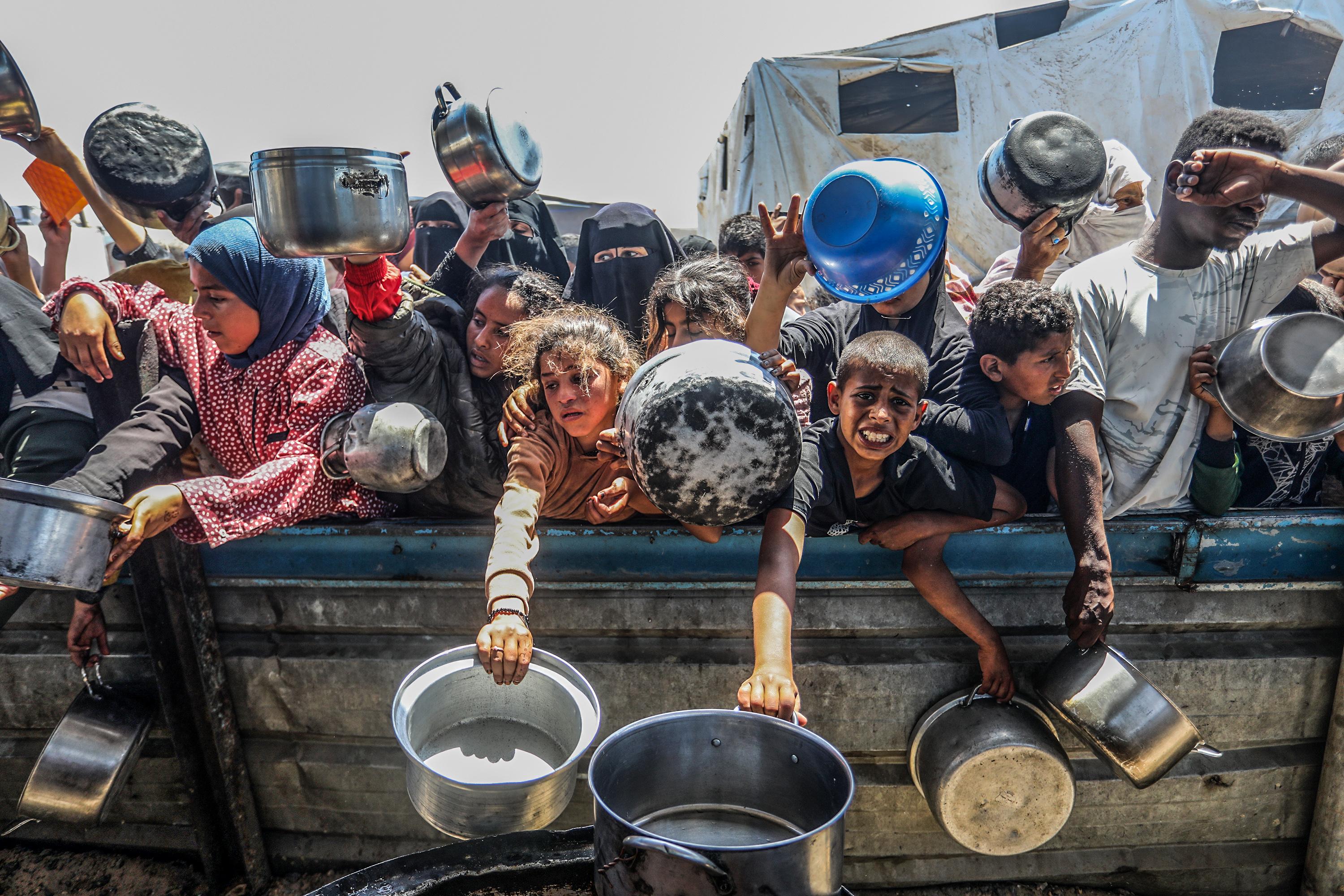 Palestinians receive meals from volunteers in the Mawasi area of ​​Khan Yunis, in the southern Gaza Strip, on April 26, 2025. 