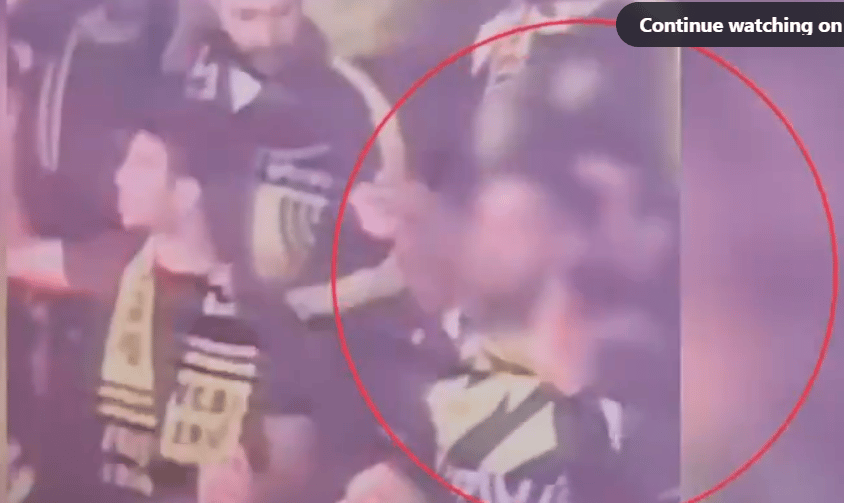 Soccer fan firing fireworks into the crowd