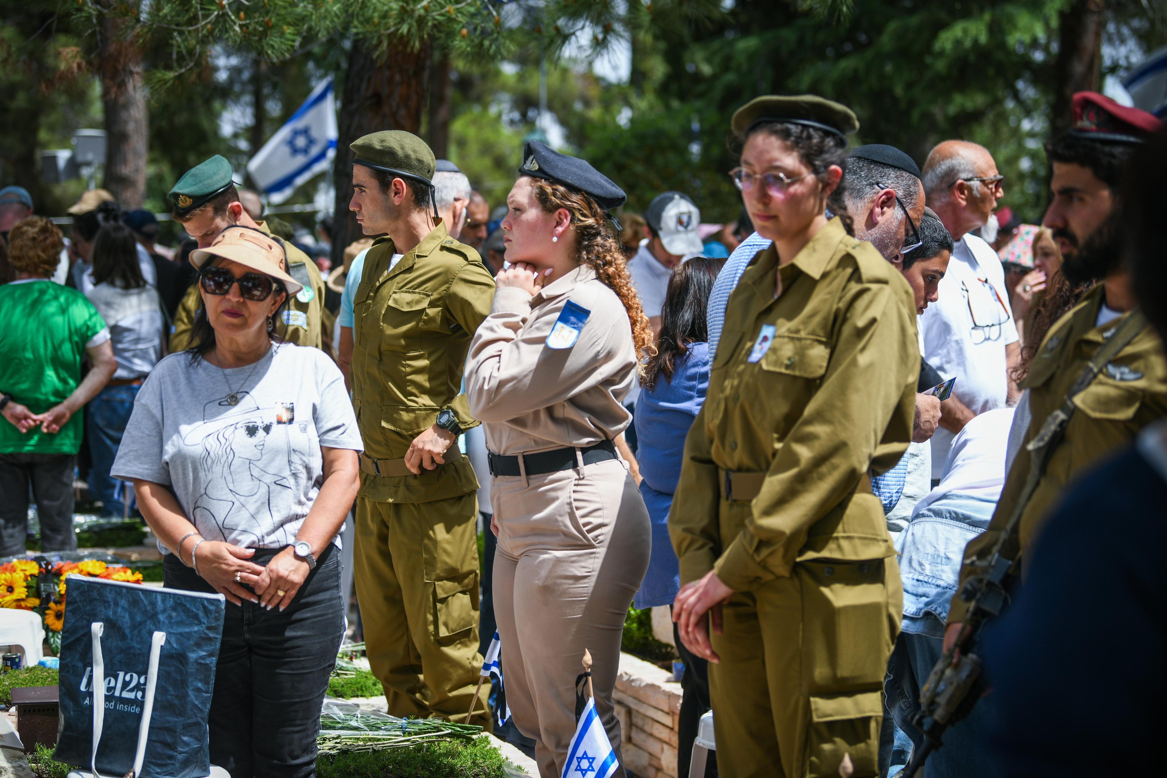 People stand still as a two minutre siren sounded across Israel, marking Memorial Day which commemorates the fallen Israeli soldiers and victims of terror at Mount Herzl Military Cemetery in Jerusalem on April 30, 2025. 