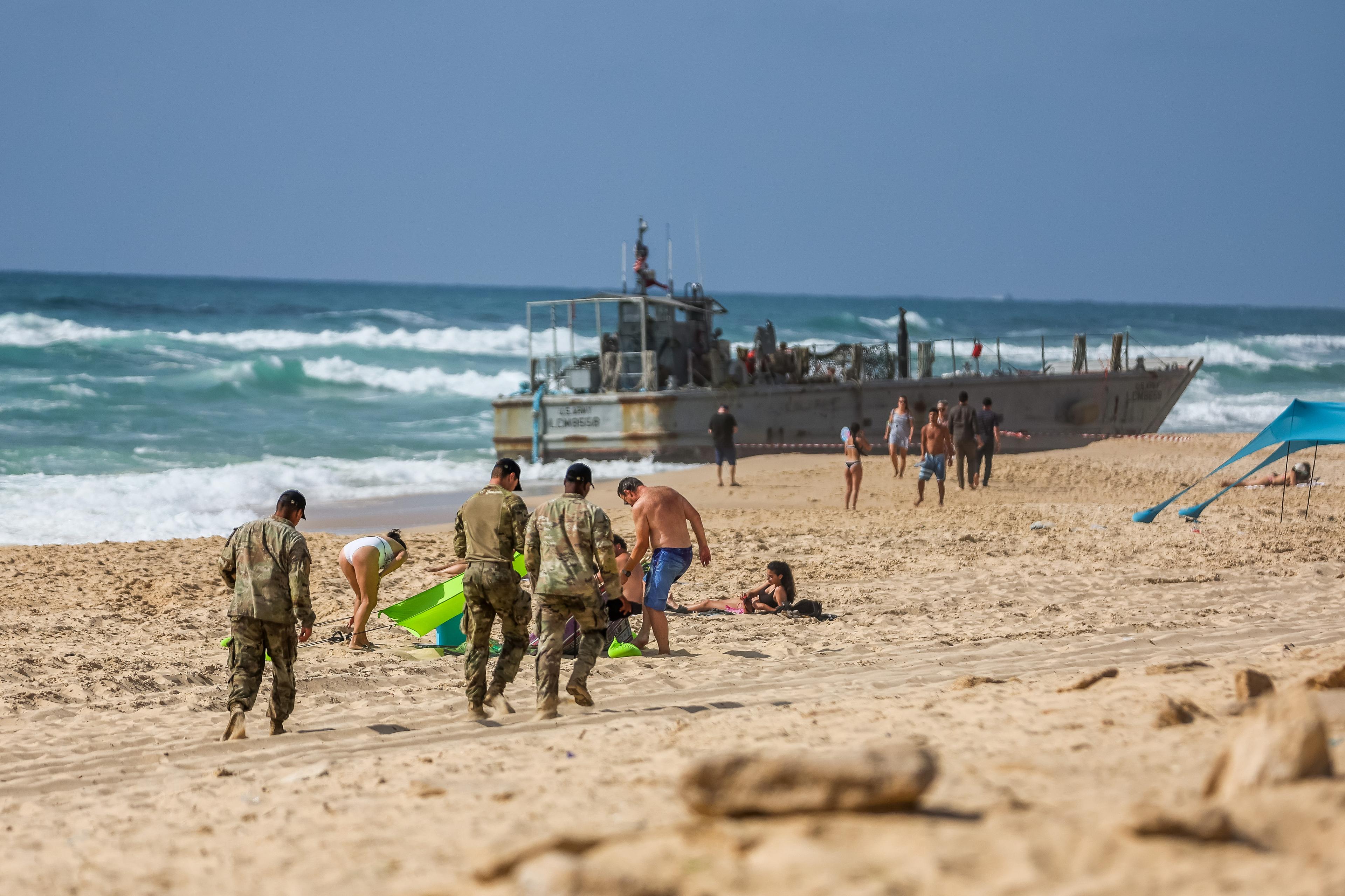 US navy soldier and Israelis near a US Army vessel that washed up on the beach in the southern Israeli city in Ashdod, May 25, 2024 US navy soldier and Israelis near a US Army vessel that washed up on the beach in the southern Israeli city in Ashdod, May 25, 2024