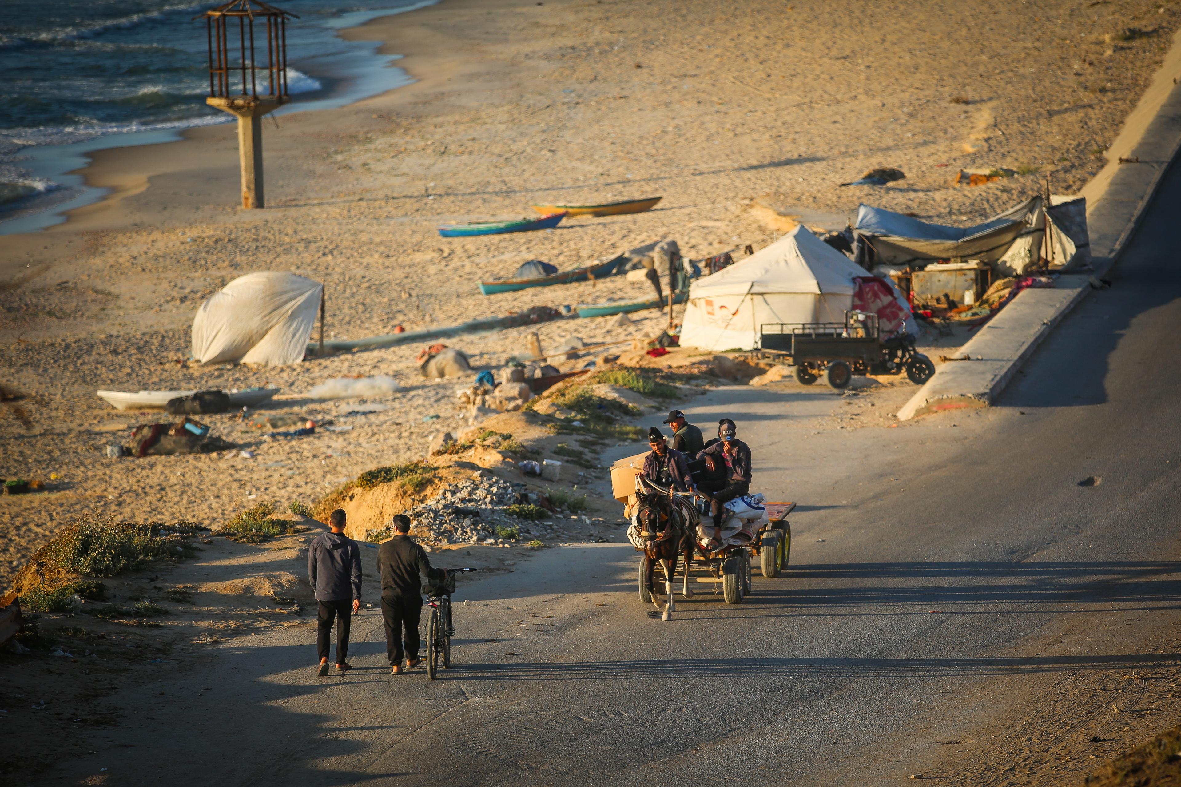 Palestinians pass through the Gaza Valley in the Nuseirat area on al-Rashid Street on May 21, 2025