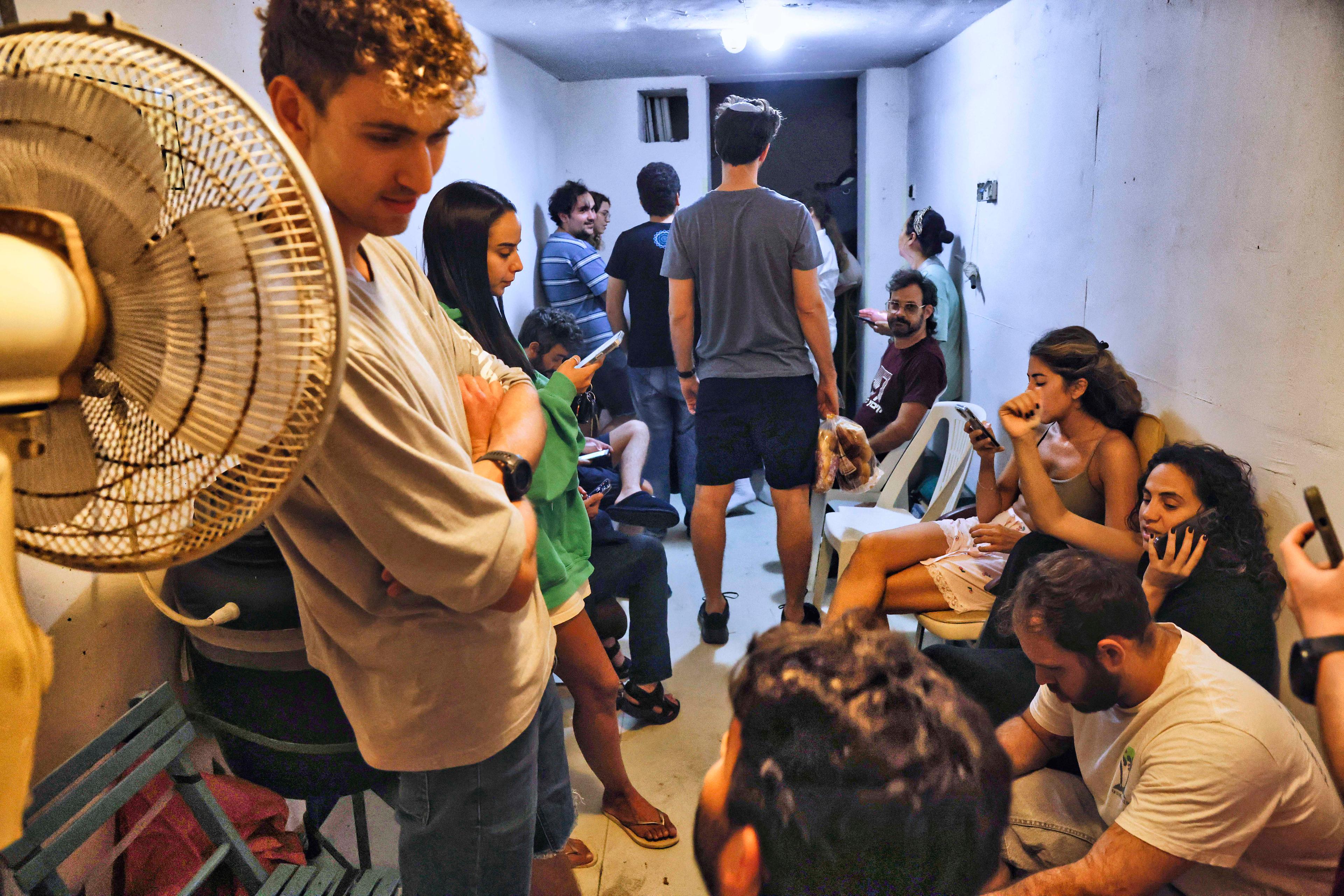 Israelis take cover inside a bomb shelter as a siren alert is sounded in Tel Aviv