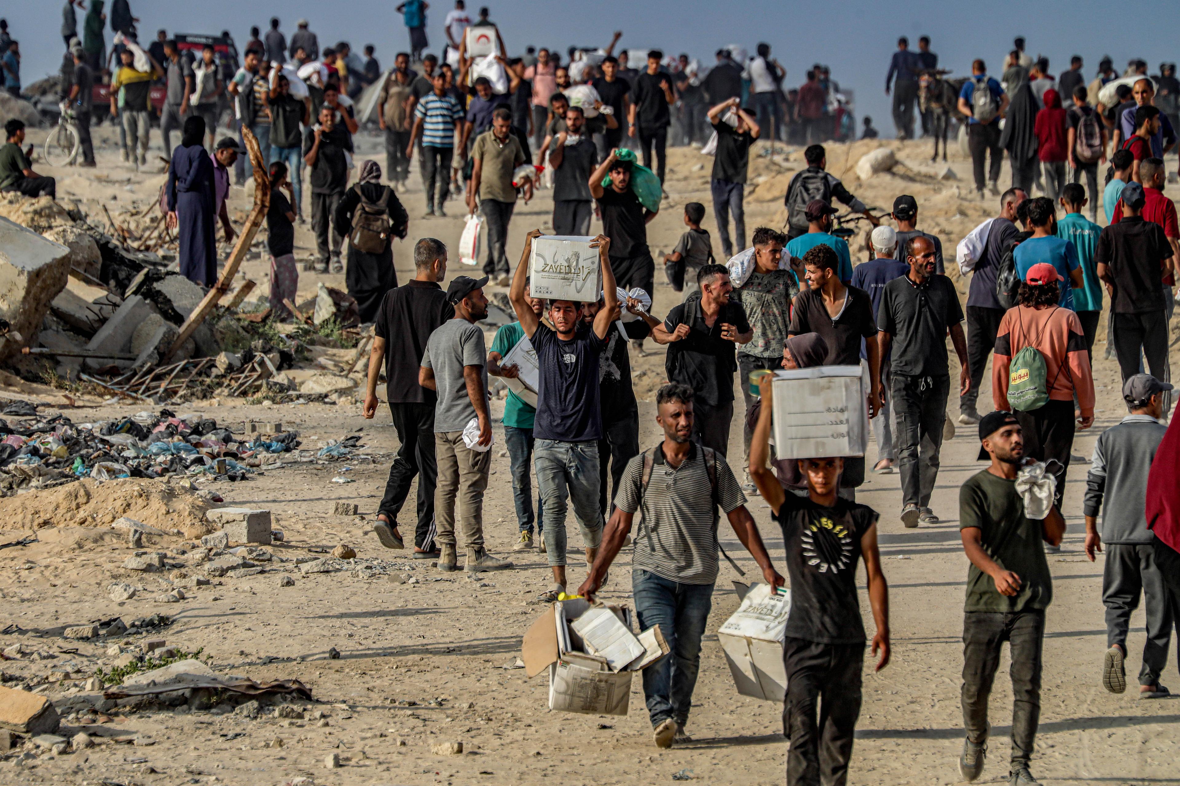 Palestinians returning home with aid.