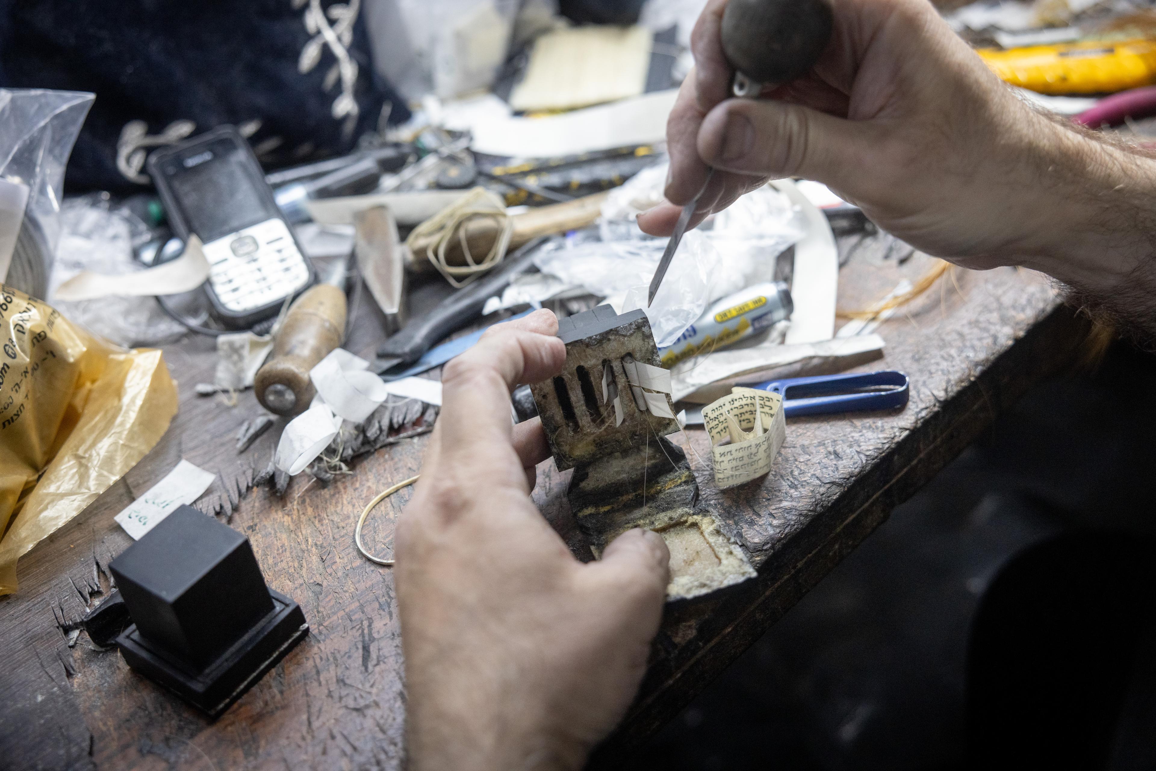 An ultra orthodox Jewish man makes tefillin in his workshop in the Meah Shearim neighborhood of Meah Shearim. June 27, 2024. 