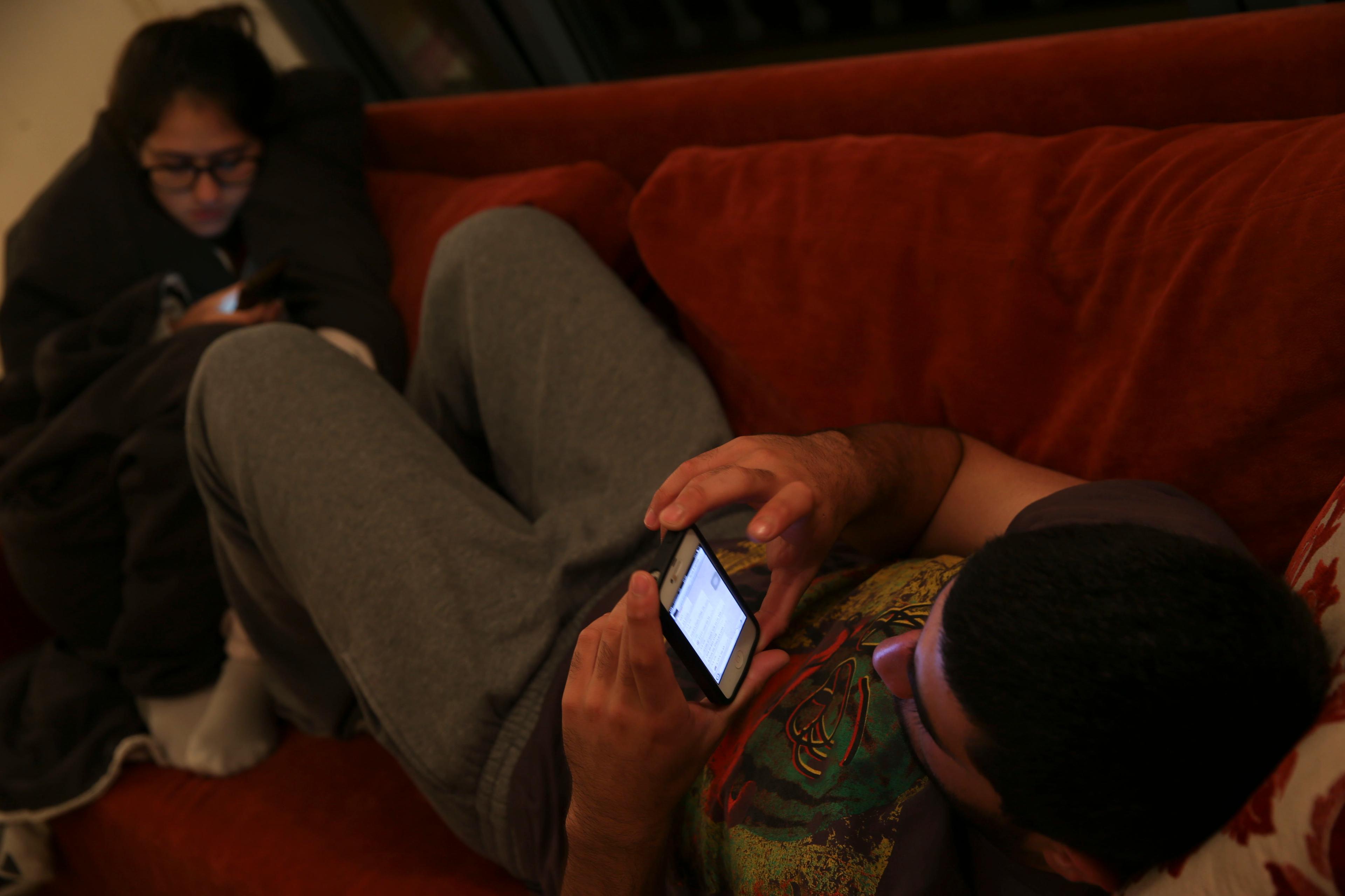 Israeli teenagers play Candy Crush their smartphones in their house room, in Tzur Hadassah on November 15, 2013.