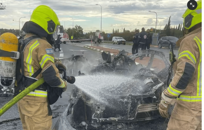 Firefighters extinguish burning car