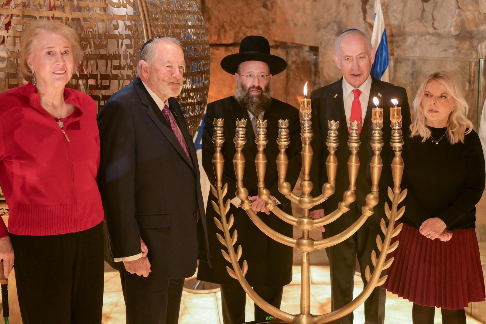 The Netanyahus, the Huckabees, and Rabbi Rabbinowitz lighting the candles at the Kotel.