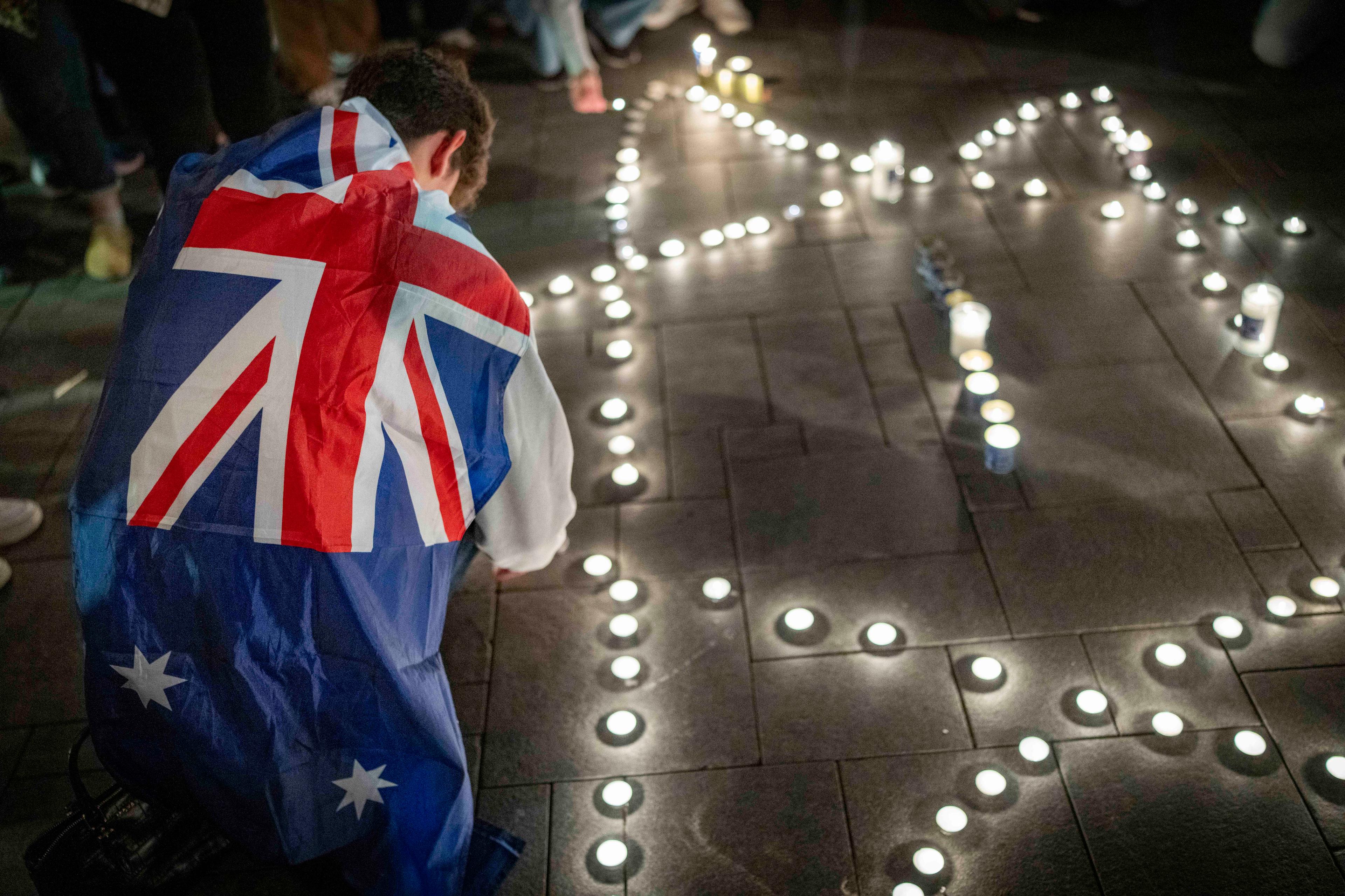 People light candles in memory of the victims of the mass shooting attack in Sydney targeting the Jewish community during Hanukkah celebrations, in Tel Aviv, on December 14, 2025.