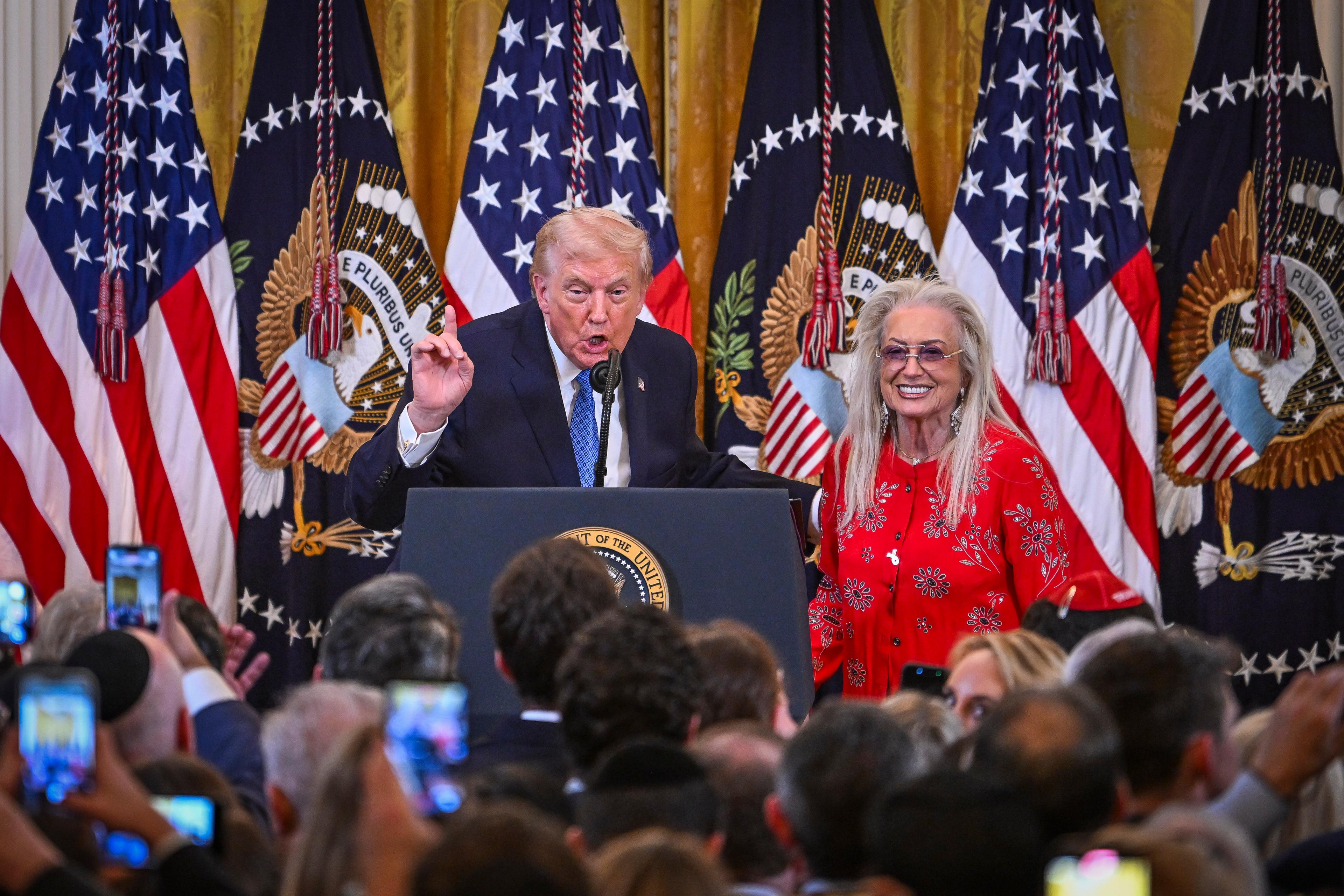 U.S. President Donald Trump and Miriam Adelson attend a Chanuka reception in the East Room of the White House in Washington, D.C., on December 16, 2025. 